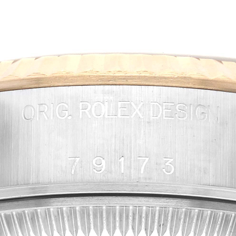 The image shows a close-up of the side engraving on the bezel and case of a Rolex Datejust 79173 Women
s Steel and Gold (two tone) Champagne Dial 79173 Women
s Steel and Gold (two tone) Champagne Dial.