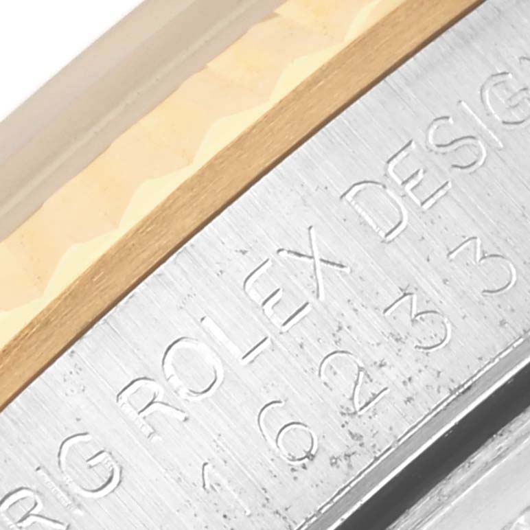 The image shows a close-up of the side of the Rolex Datejust 16233 Men's Steel and Gold (two tone) Beige Dial 16233 Men's Steel and Gold (two tone) Beige Dial, highlighting the engraved letters and the metal edge.