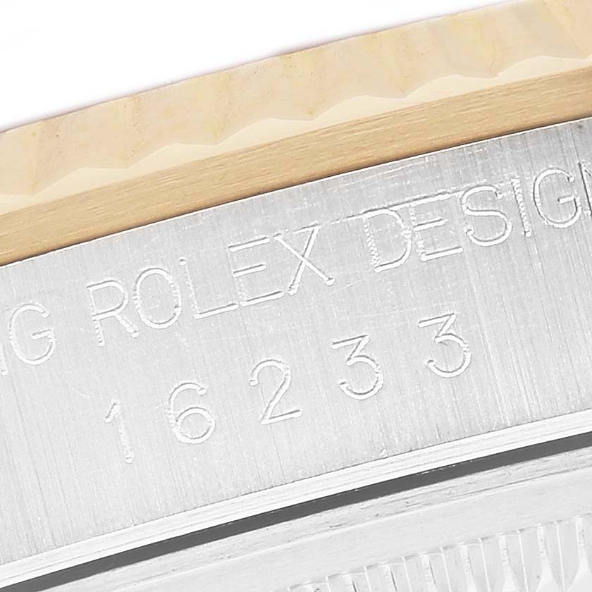 The image shows an angled close-up of the side of a Rolex Datejust 16233 Men's Steel and Gold (two tone) White Dial 16233 Men's Steel and Gold (two tone) White Dial, featuring engraved text on the case and part of the bezel.