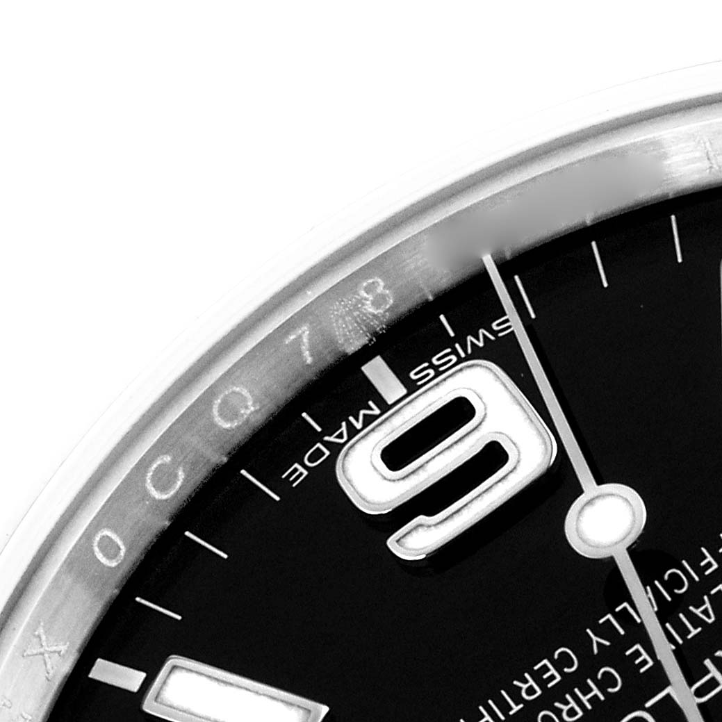 The image shows a close-up of the Rolex Explorer 214270 Men
s Stainless Steel Black Dial 214270 Men
s Stainless Steel Black Dial watch, focusing on the dial around the 9 o
clock marker and some of the bezel.