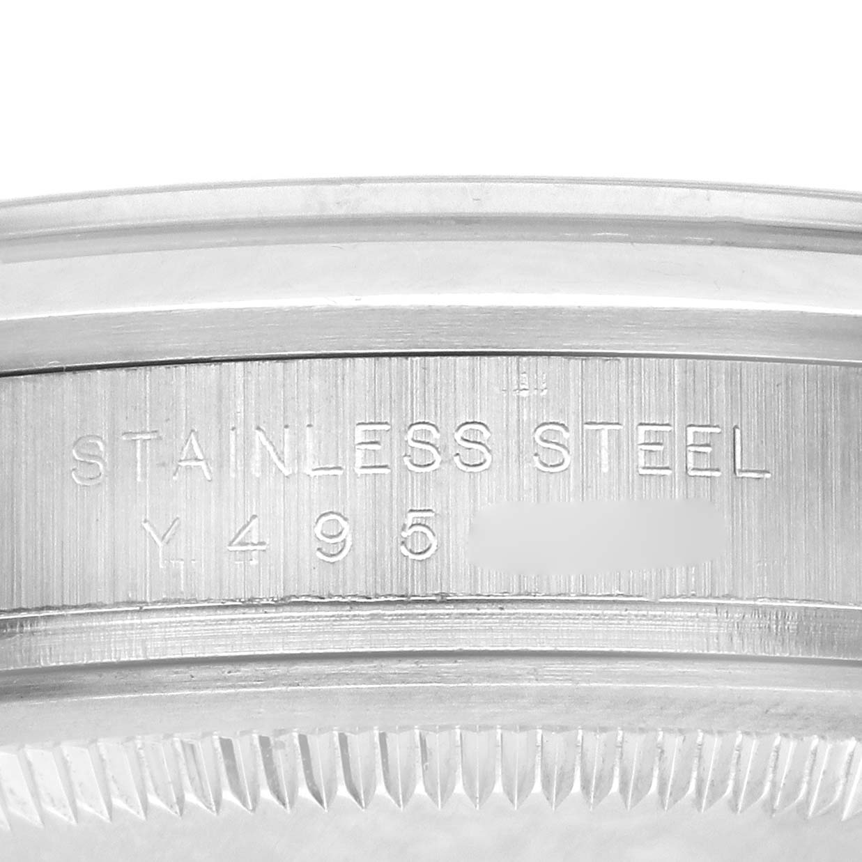The image shows a close-up of the engraved case edge of a Rolex Explorer 114270 Men's Stainless Steel Black Dial 114270 Men's Stainless Steel Black Dial watch, highlighting "STAINLESS STEEL" and a serial number.