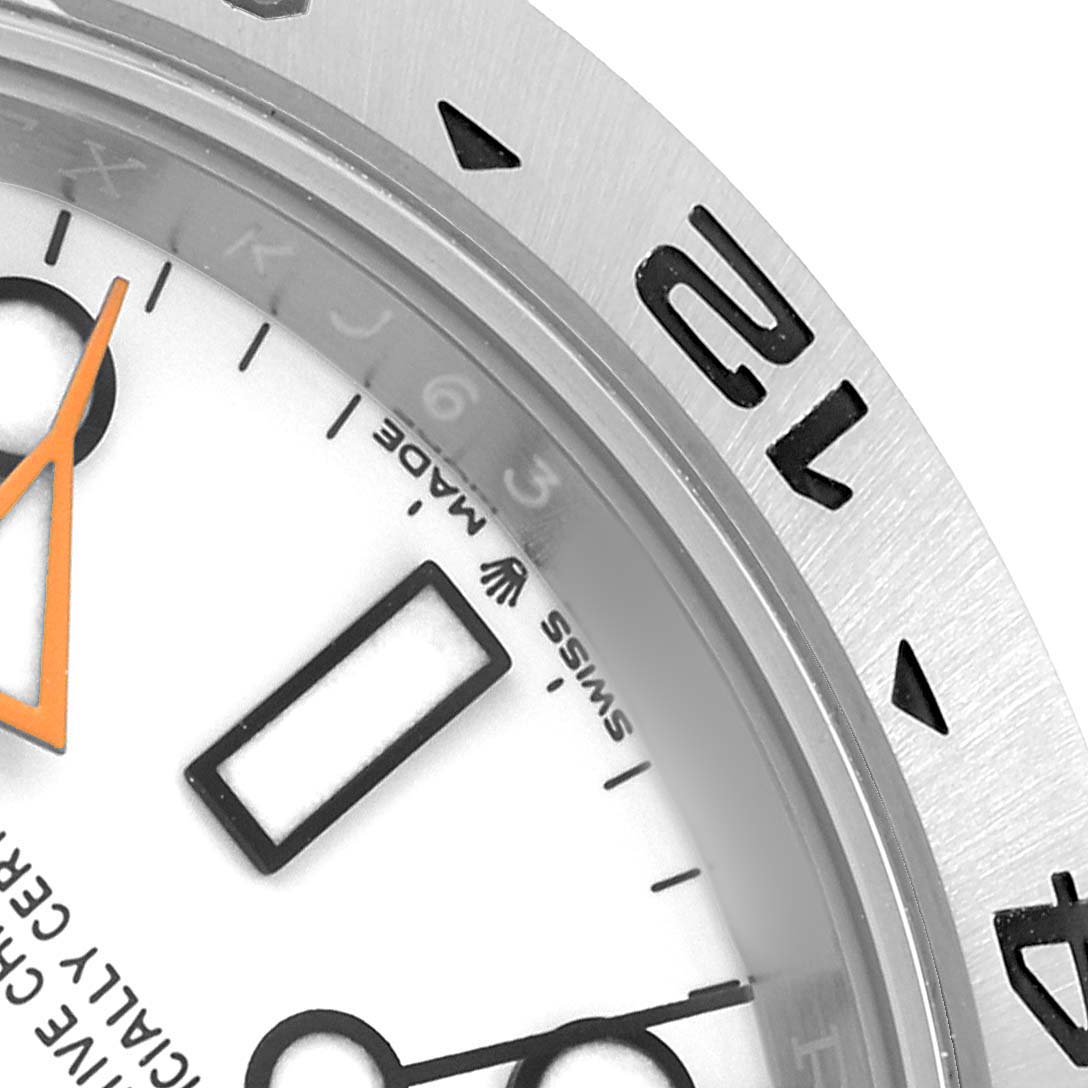 The image shows a partial view of the Rolex Explorer 226570 Men's Stainless Steel White Dial watch face and bezel at an angle, highlighting the indices and numerals.