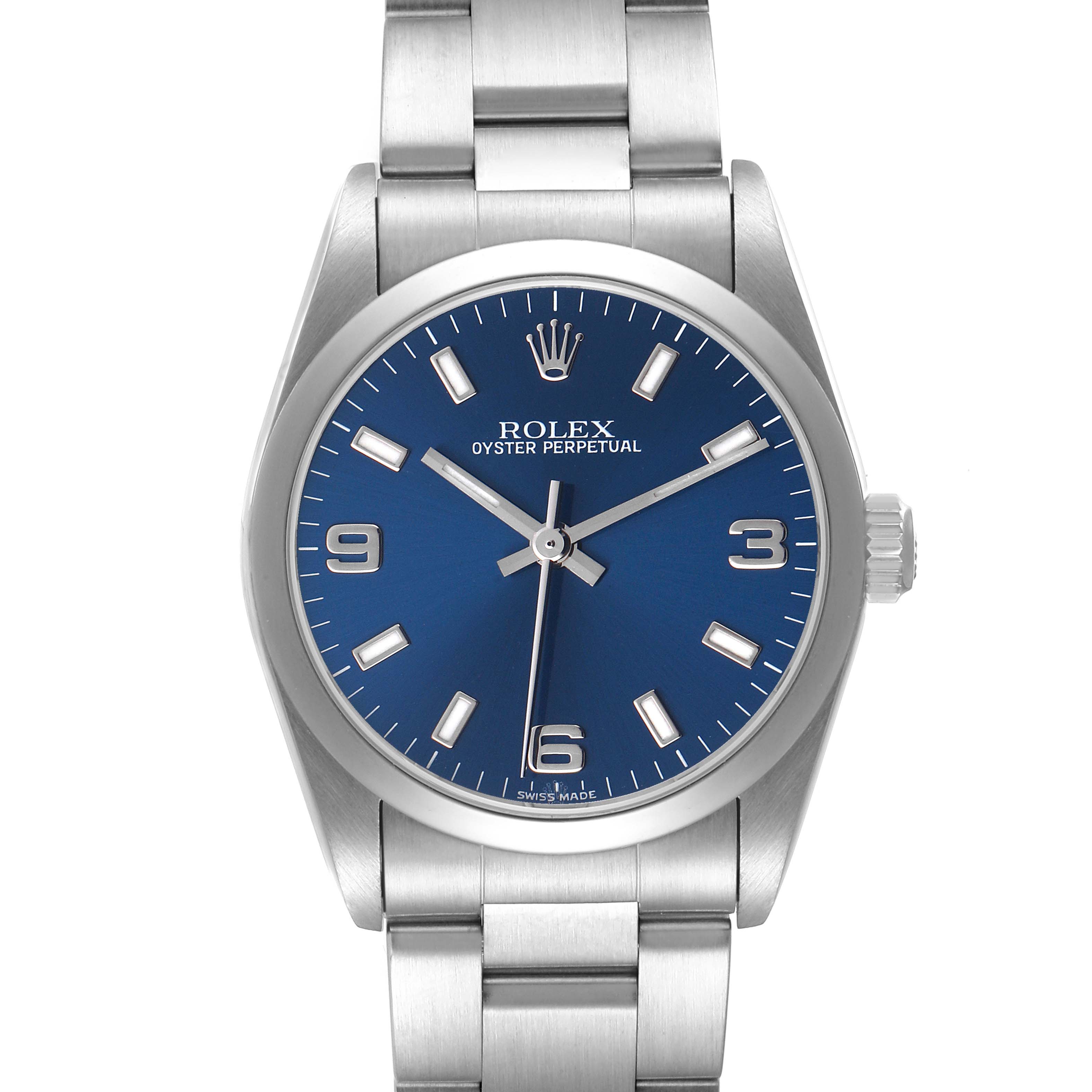 The Rolex Oyster Perpetual 77080 Women's Stainless Steel Blue Dial watch is shown from a top-down angle, highlighting the blue dial, bezel, and part of the bracelet.