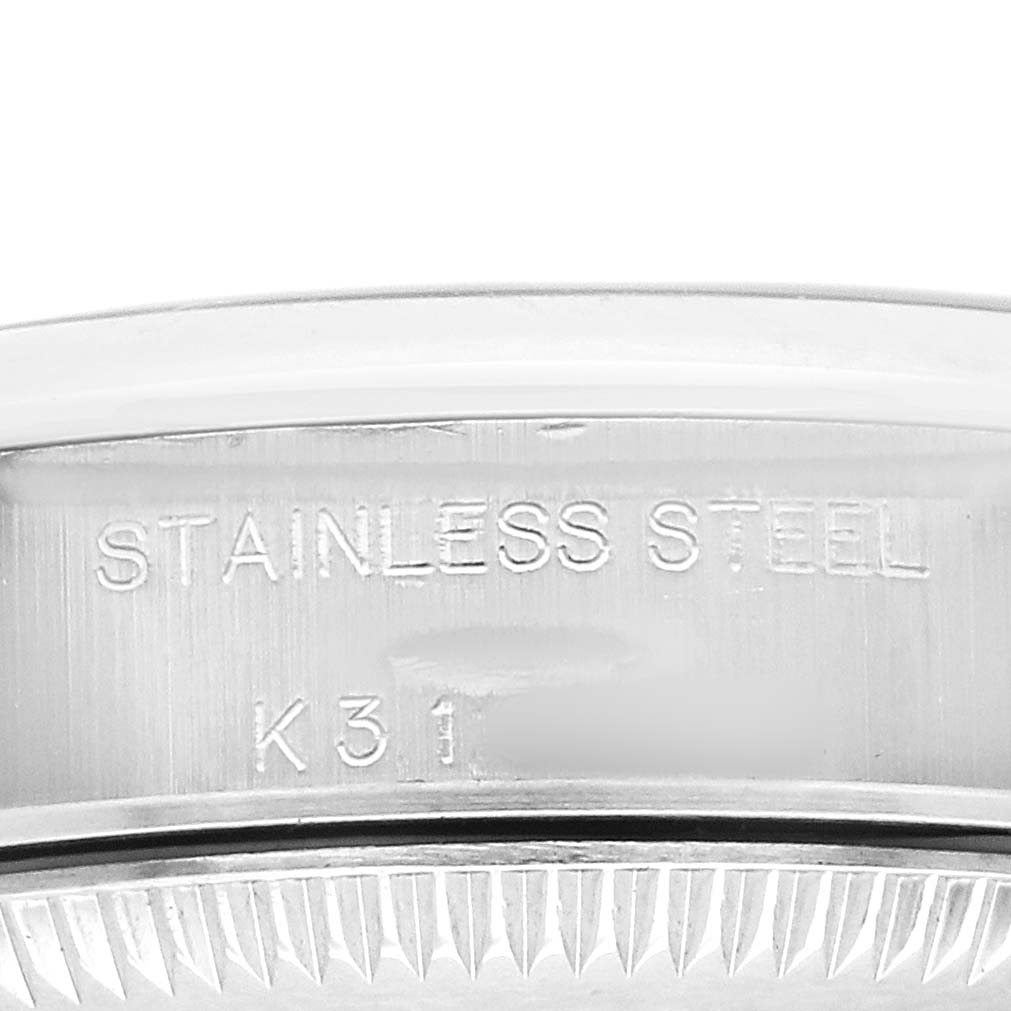 The image shows a close-up of the case back edge on the Rolex Oyster Perpetual 76080 Women's Stainless Steel Blue Dial, highlighting "Stainless Steel" engraving.