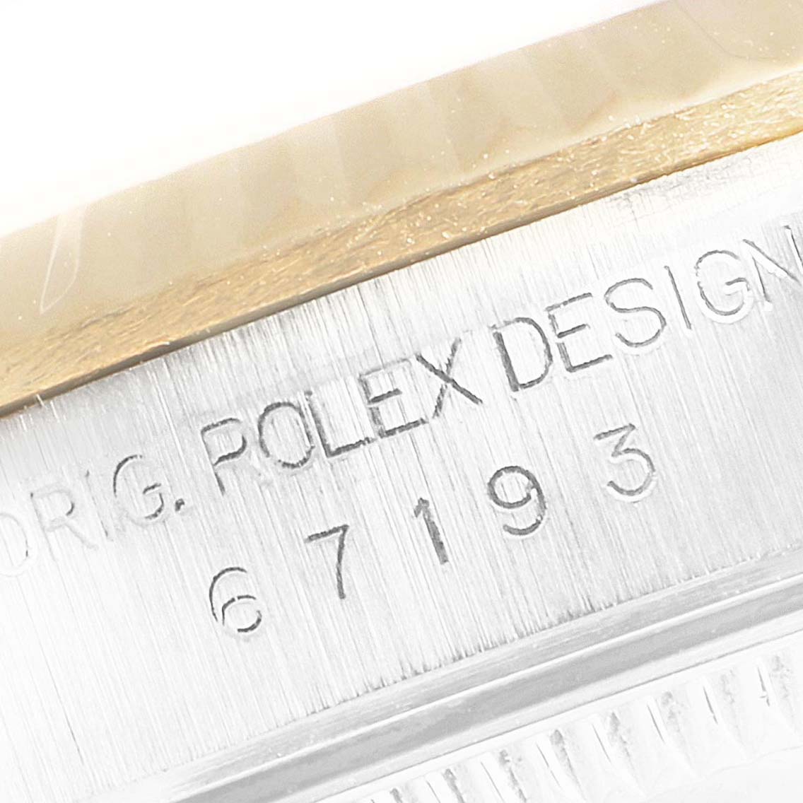 This image shows a close-up of the engraving and bezel of a Rolex Oyster Perpetual 67193 Women's Steel and Gold (two tone) Champagne Dial 67193 Women's Steel and Gold (two tone) Champagne Dial watch.