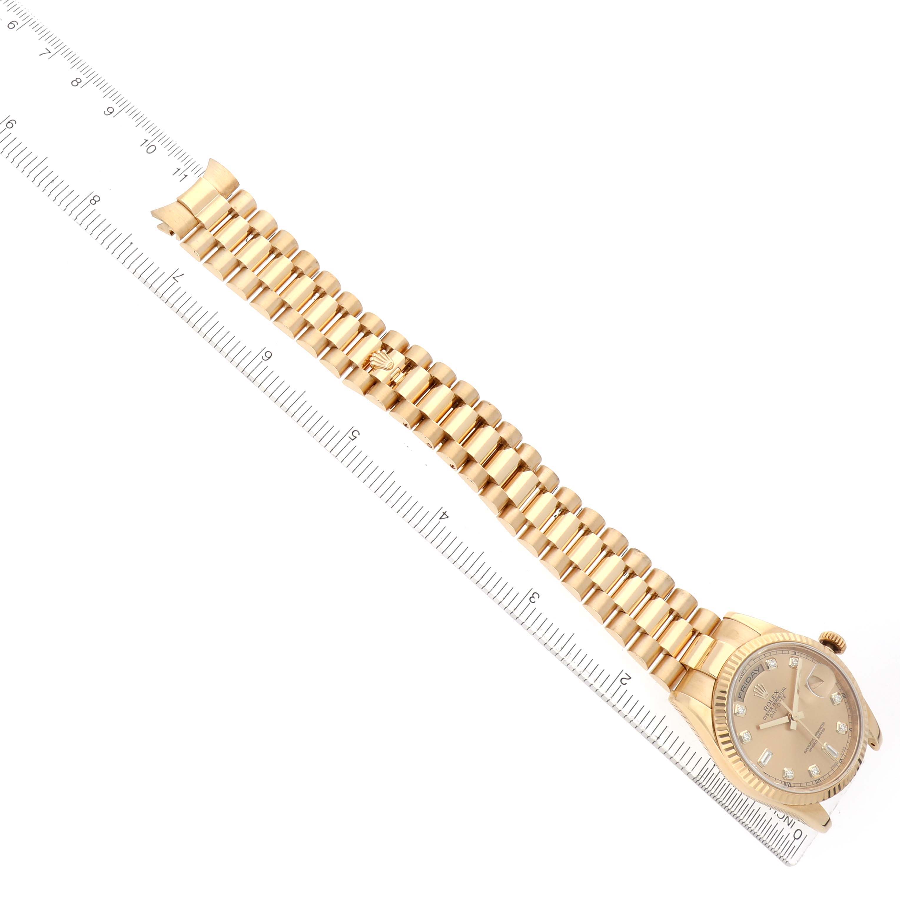 The Rolex President 118238 Men's Yellow Gold Champagne Dial watch is shown from an overhead angle, displaying the full bracelet, dial, and part of the case next to a ruler.
