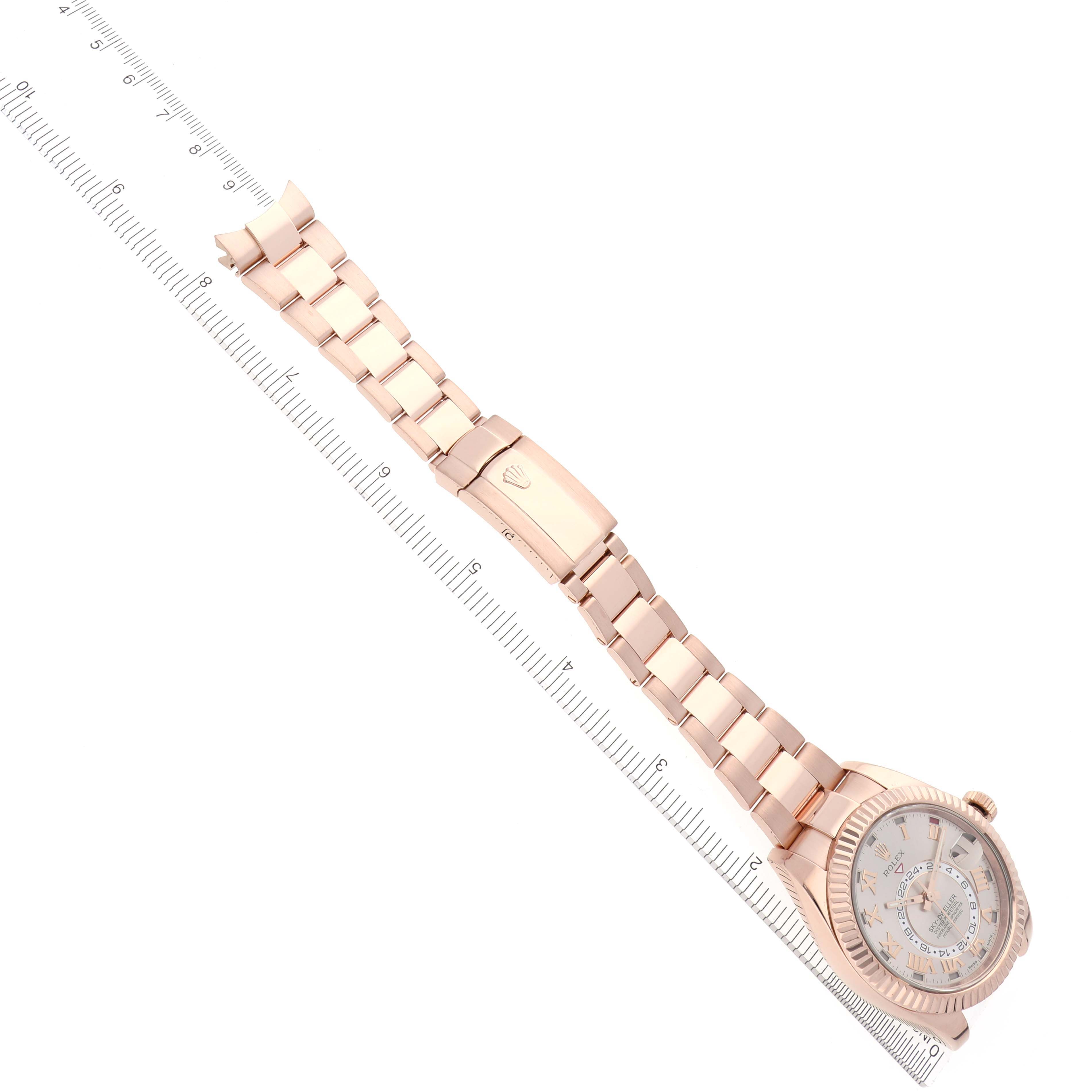 The Rolex Sky-Dweller 326935 Men's Rose Gold Pink Dial 326935 Men's Rose Gold Pink Dial watch is shown from a top-down angle, displaying the entire bracelet, clasp, and face.