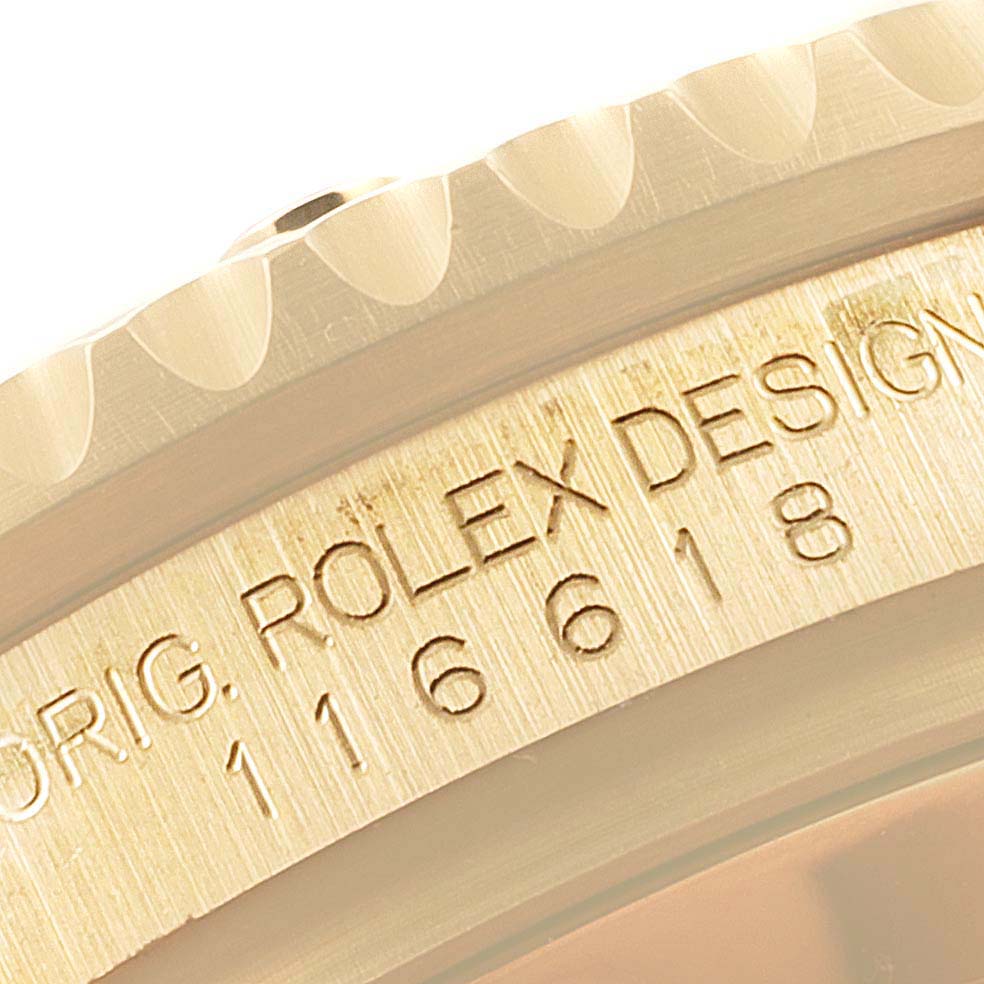 This close-up image shows the engraved model number and part of the bezel of a Rolex Submariner 116618 Men
s Yellow Gold Black Dial 116618 Men
s Yellow Gold Black Dial watch.