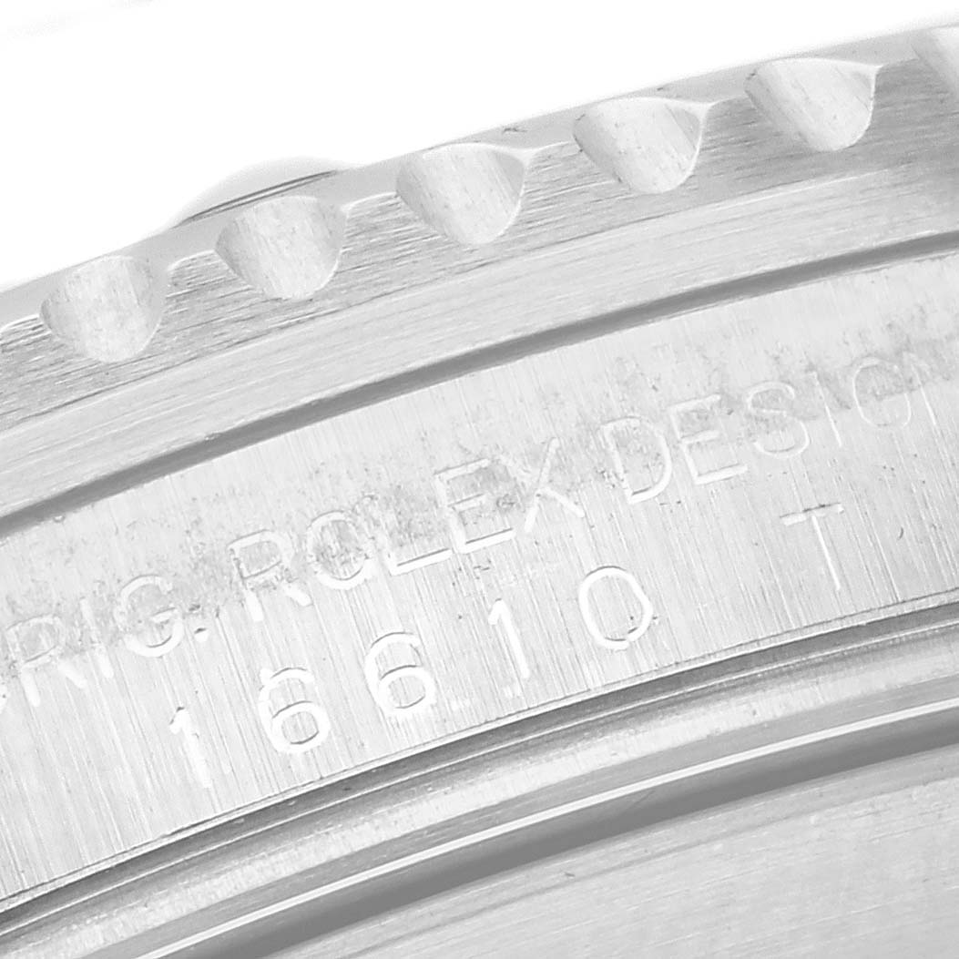 The image shows a close-up of the engraved side of the bezel on a Rolex Submariner 16610 Men
s Stainless Steel Black Dial 16610 Men
s Stainless Steel Black Dial watch.