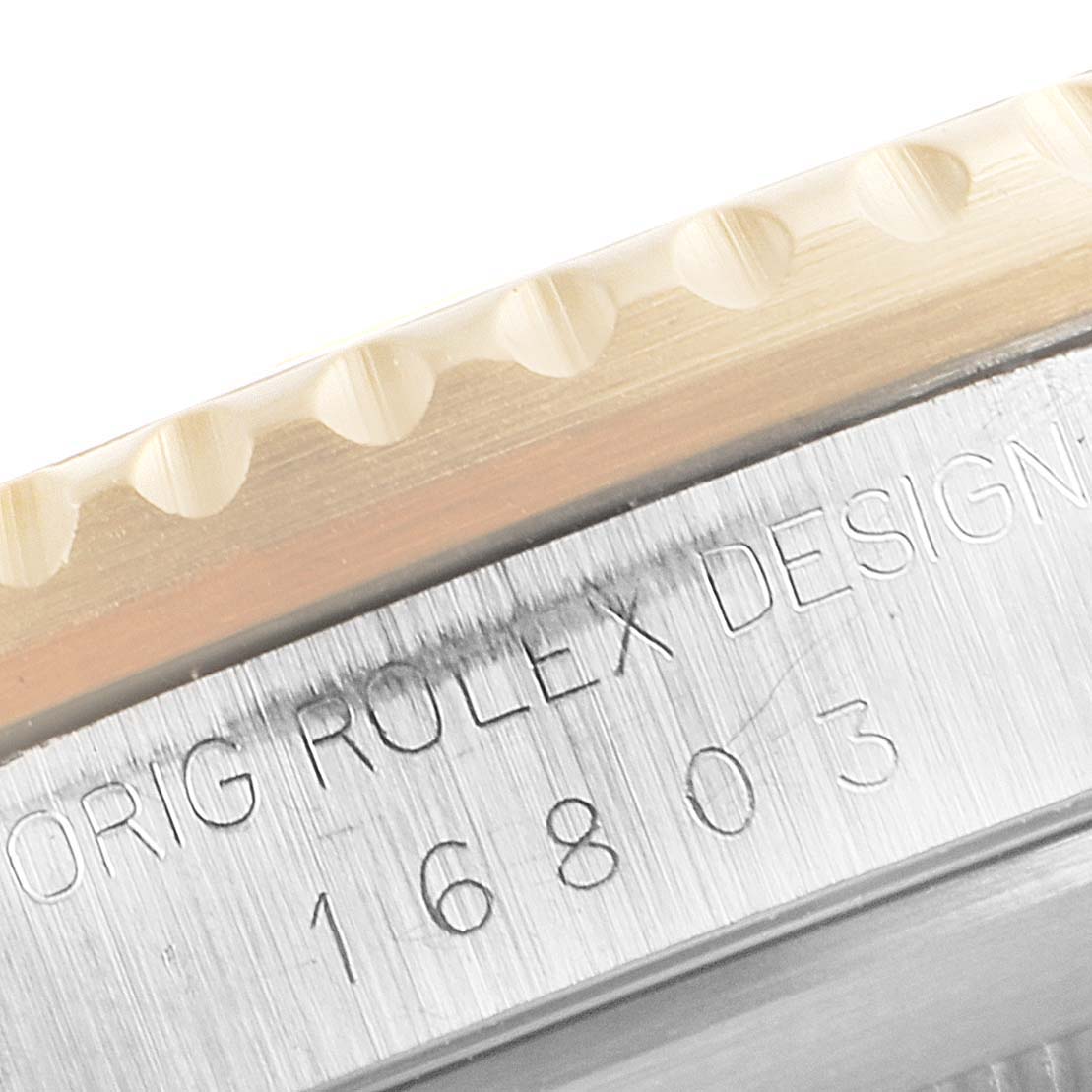 This image shows a close-up of the engraved edge and bezel of a Rolex Submariner 16803 Men's Steel and Gold (two tone) Black Dial 16803 Men's Steel and Gold (two tone) Black Dial model 16803.