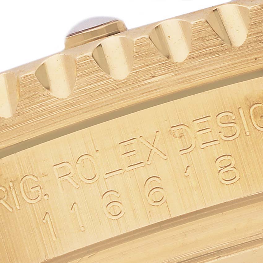 The image shows a close-up of the Rolex Submariner 116618LB Men's Yellow Gold Blue Dial 116618LB Men's Yellow Gold Blue Dial's bezel edge and engraved design markings.