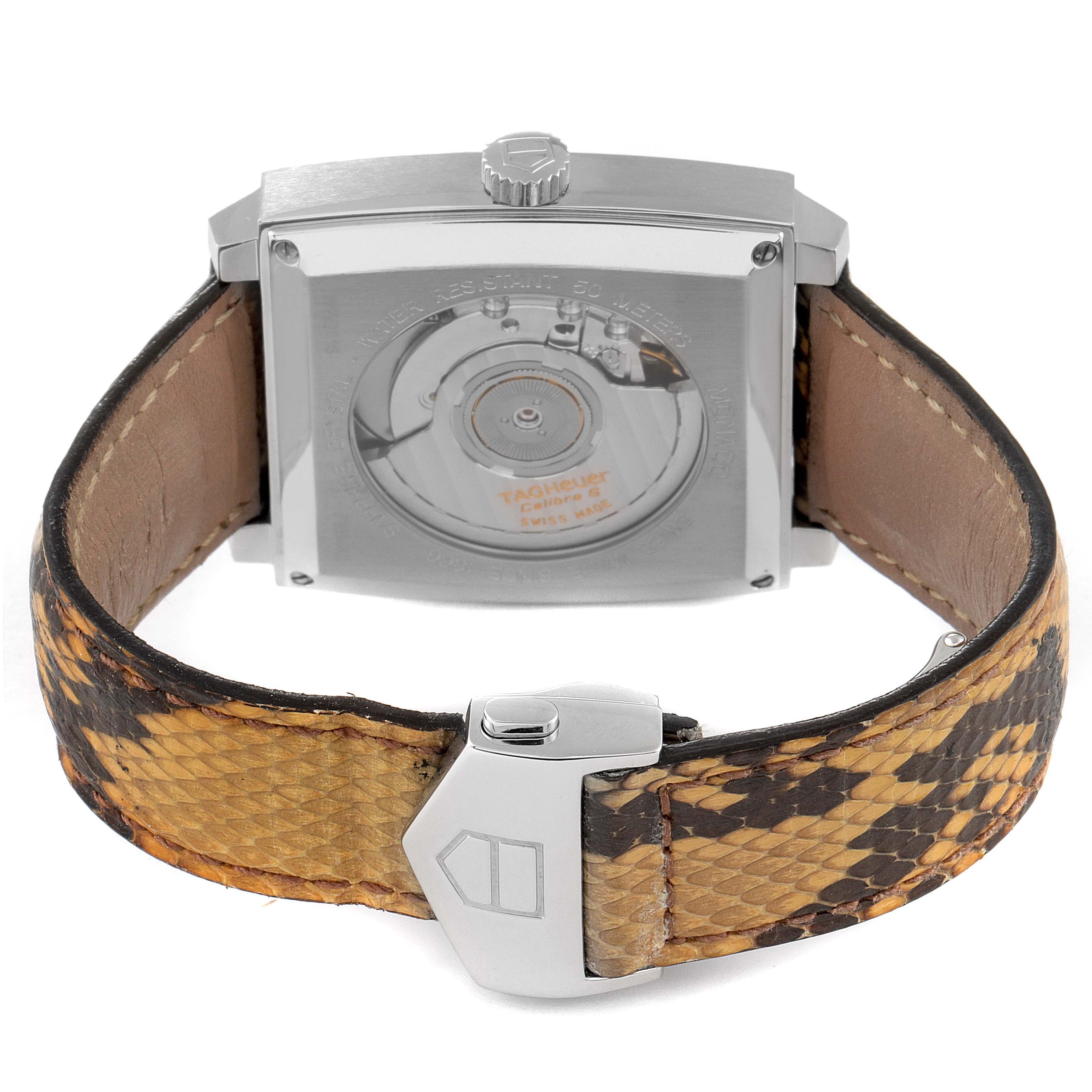 The image shows the back view of the Tag Heuer Monaco WW2115.FC6217 Men's Stainless Steel Brown Dial WW2115.FC6217 Men's Stainless Steel Brown Dial watch, featuring the case back and a textured leather strap with a clasp.