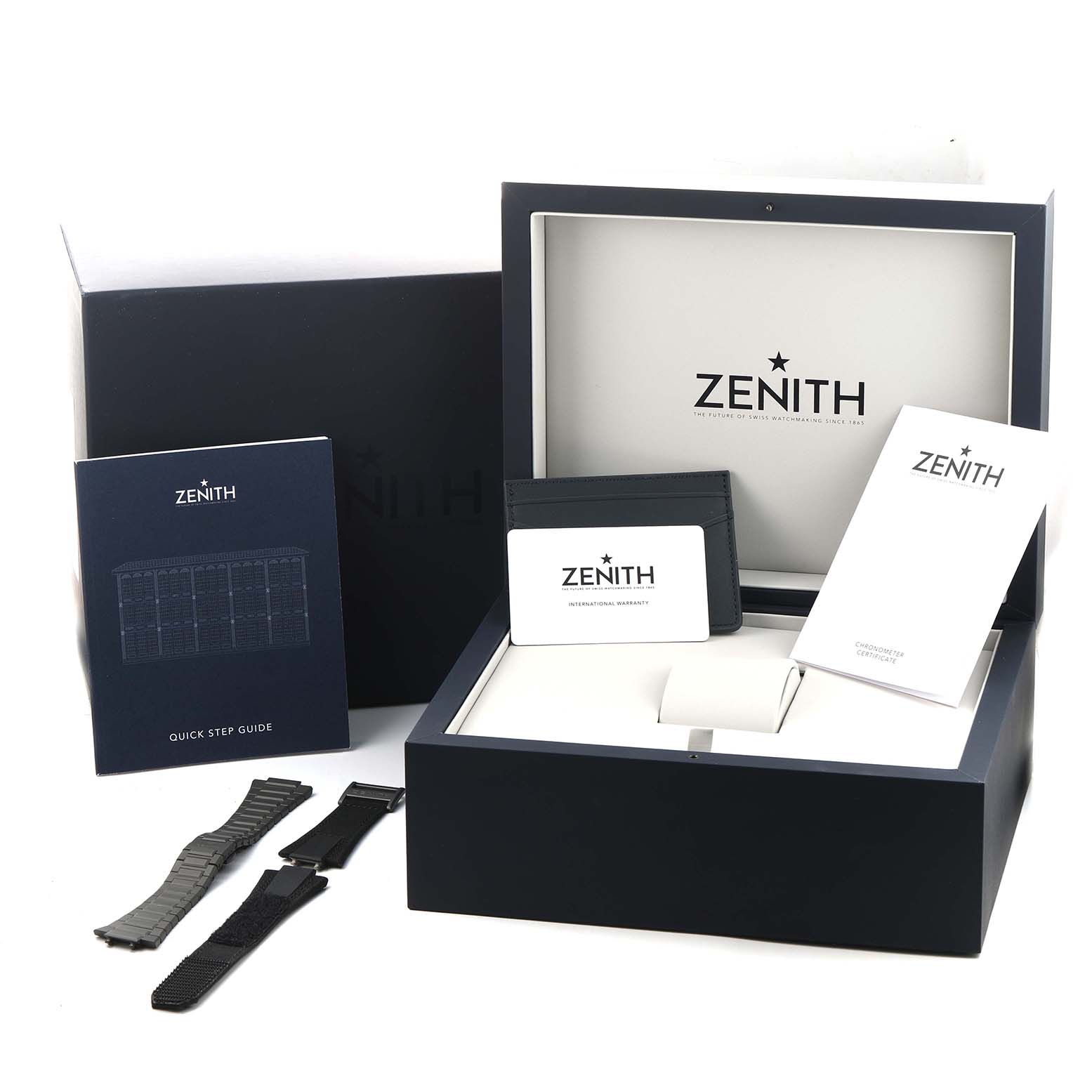 The image shows Zenith Defy 97.9100.9004/02.I001 Men's Titanium Grey Dial packaging including a box, additional straps, a quick guide, certificates, and a cardholder.