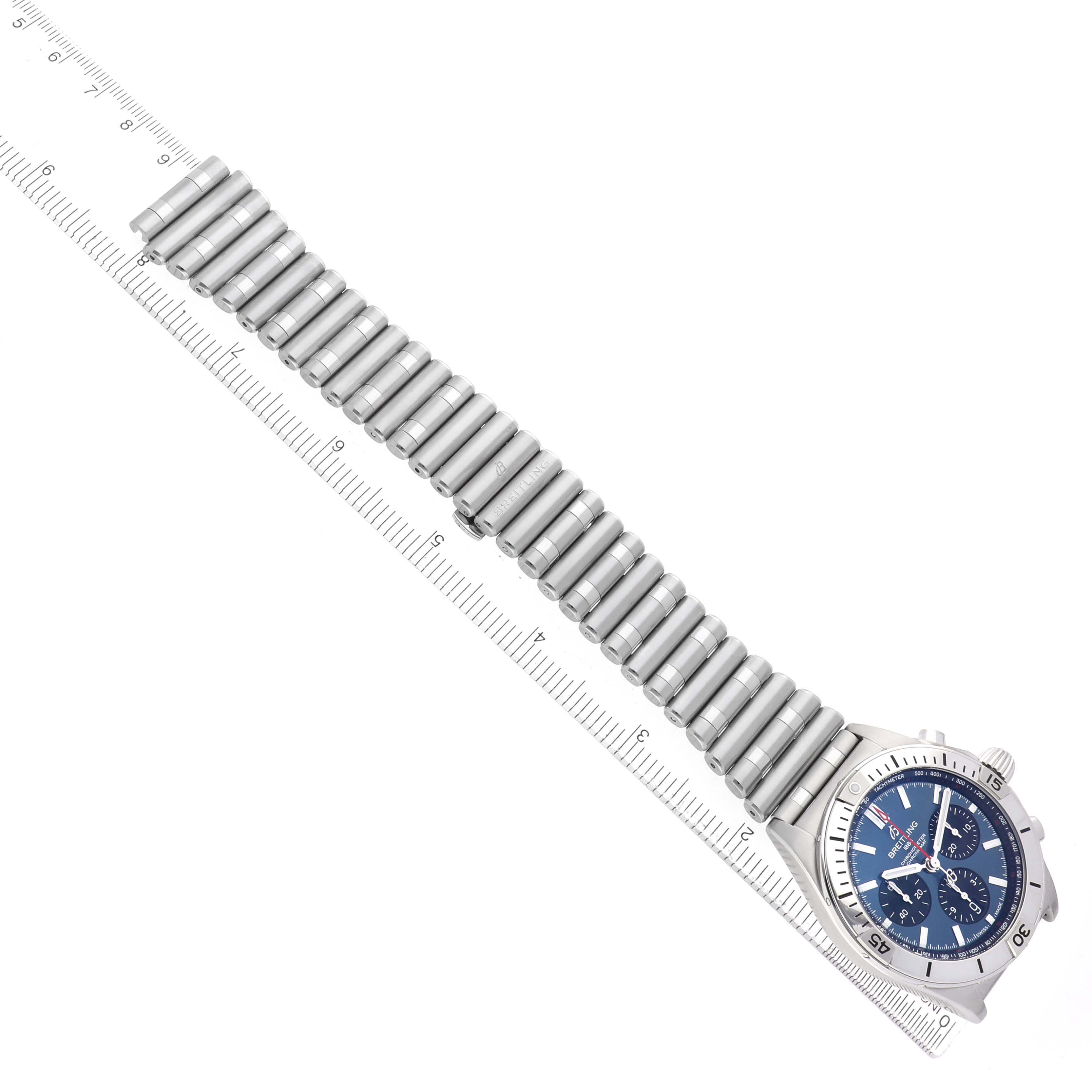 The Breitling Chronomat AB0134101C1A1 Men's Stainless Steel Blue Dial watch is shown from a top view, highlighting the bracelet and face alongside a measuring ruler.