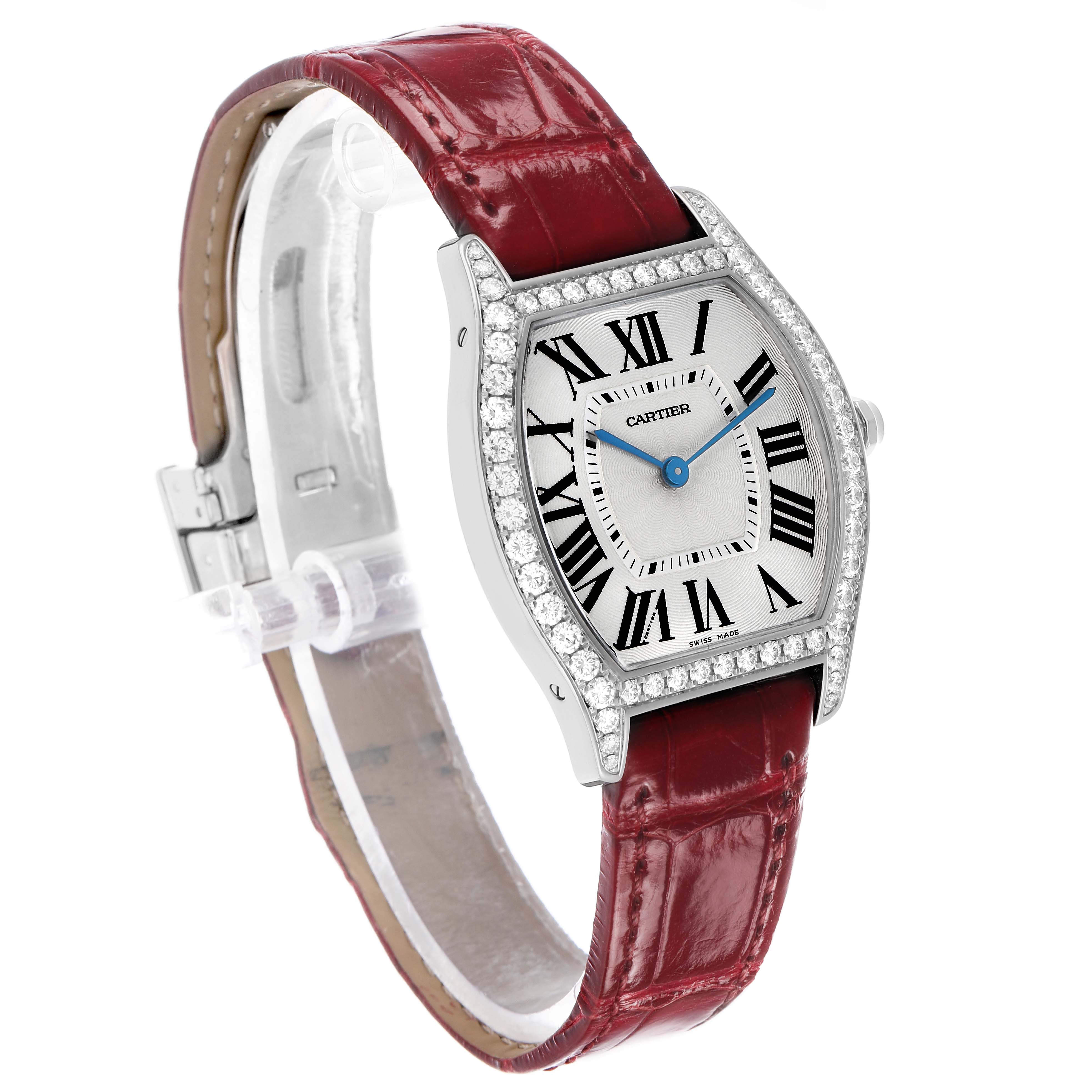 The Cartier Tortue WA501009 Women's White Gold Silver Dial watch is shown at a three-quarter angle, displaying the face, diamond bezel, and red leather strap.