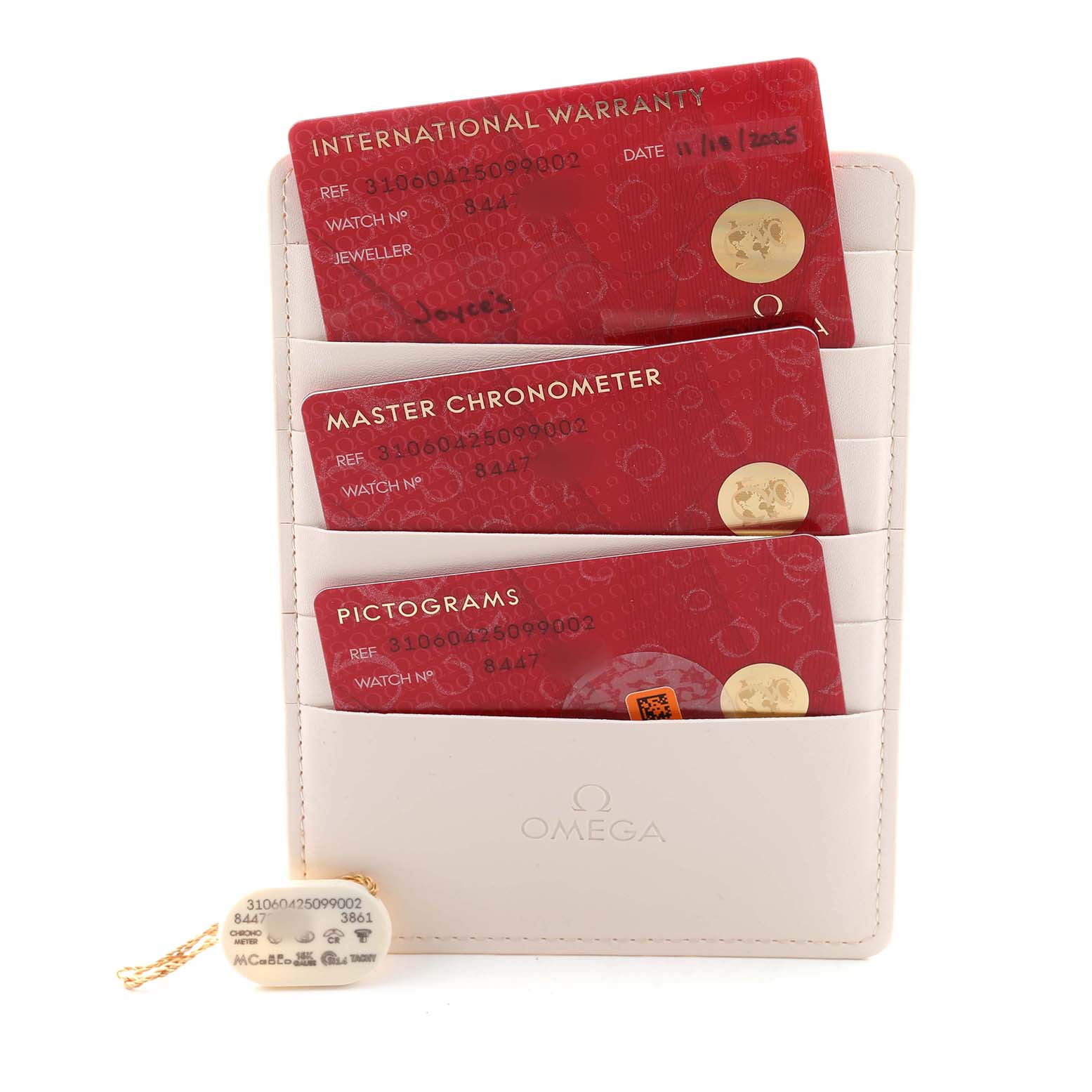 The image shows Omega Speedmaster 310.62.42.50.99.001 Men's Yellow Gold Champagne Dial watch cards: International Warranty, Master Chronometer, and Pictograms, in a beige card holder.