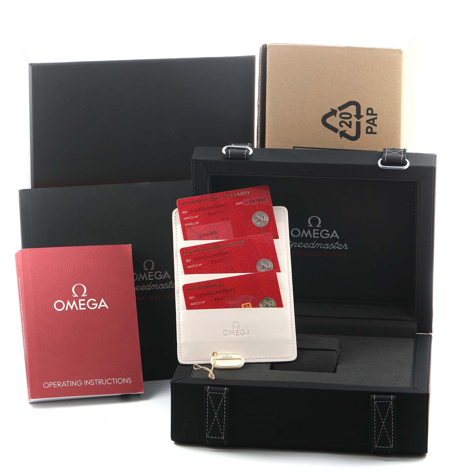 The image shows the Omega Speedmaster 310.62.42.50.99.001 Men's Yellow Gold Champagne Dial packaging, including boxes, a manual, cards, and a case from a front angle.