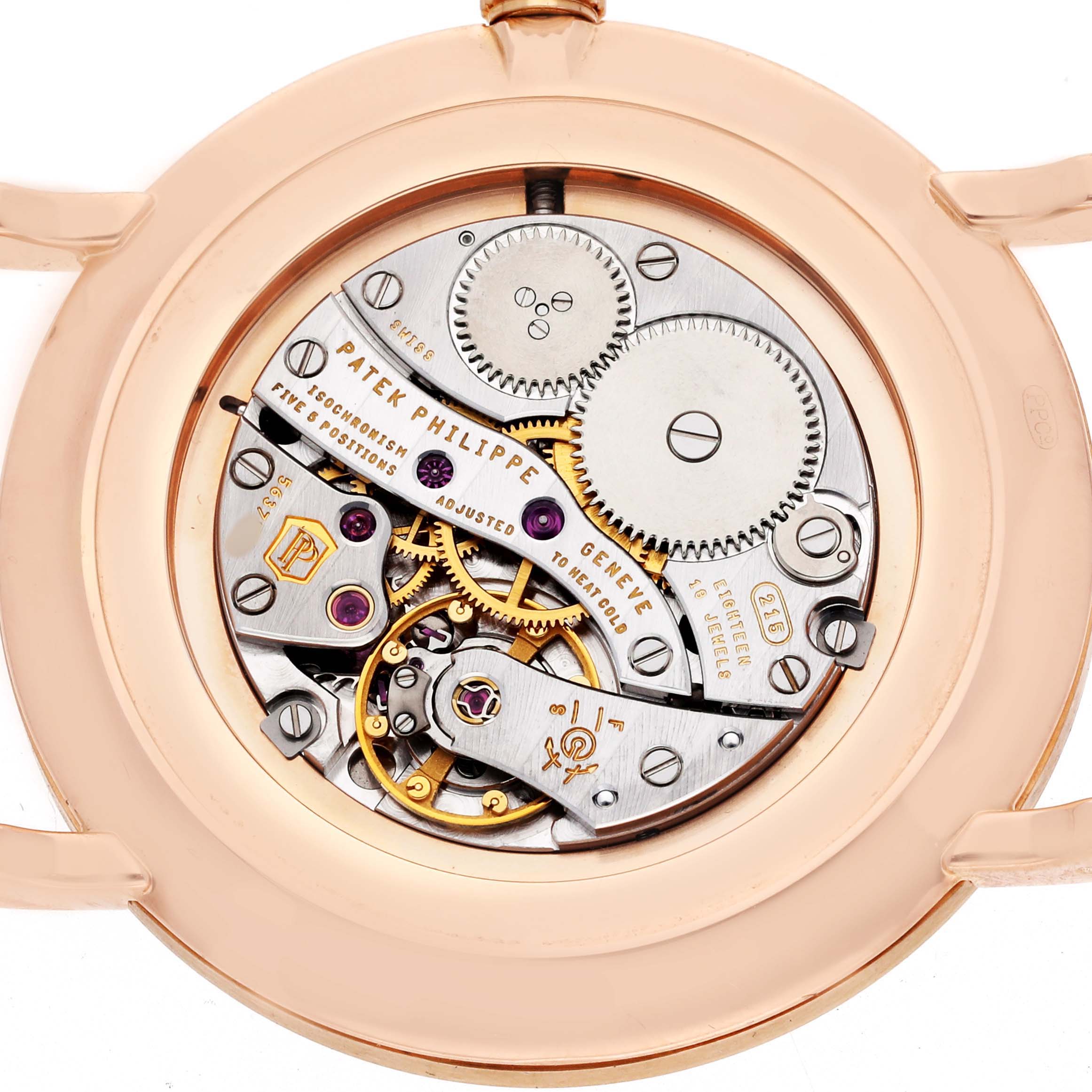 The image shows the back view of a Patek Philippe Calatrava 5119R-001 Men's Rose Gold White Dial watch, revealing its intricate movement and gears.