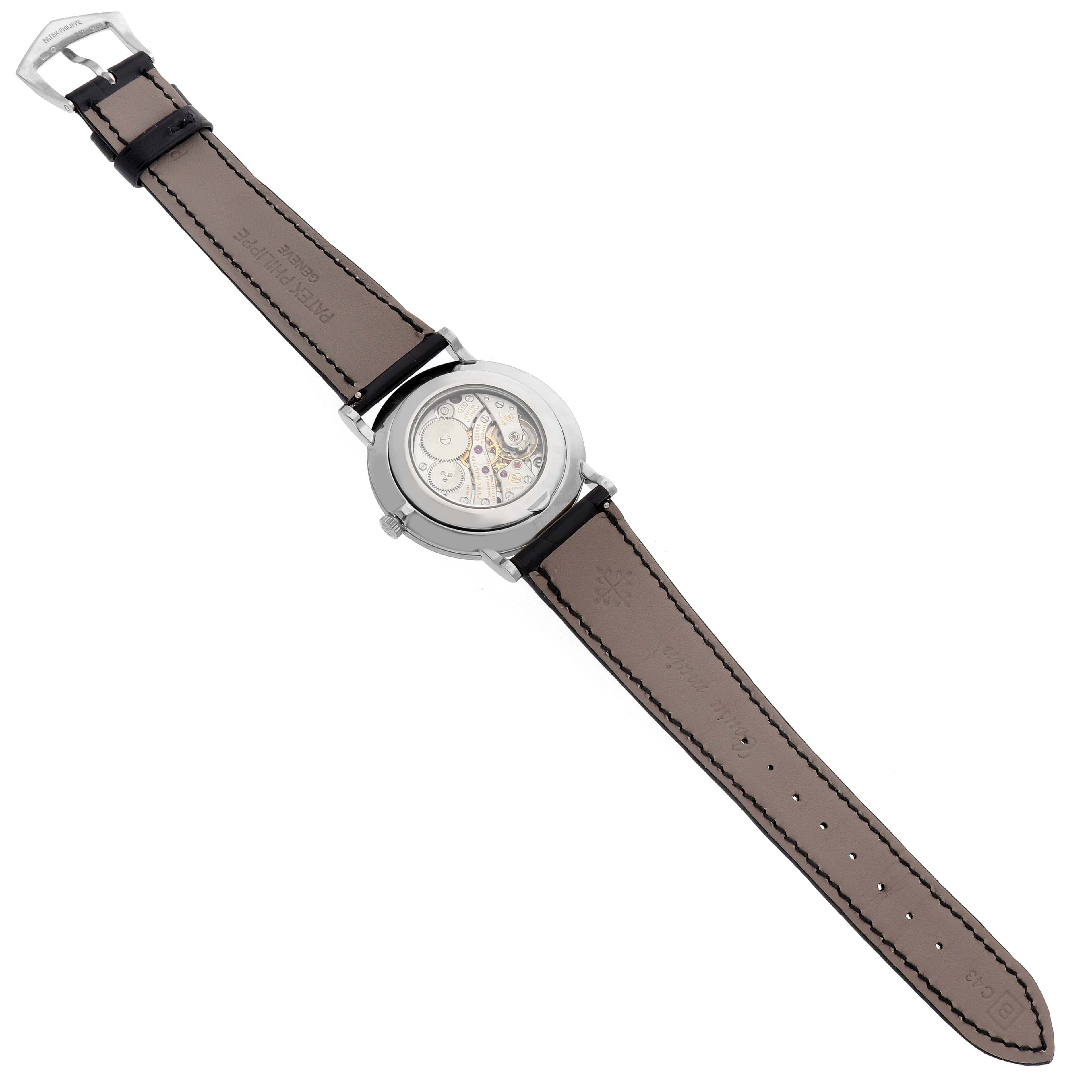 The Patek Philippe Calatrava 5119G-001 Men's White Gold White Dial watch is shown from the back, revealing its movement and the leather strap.