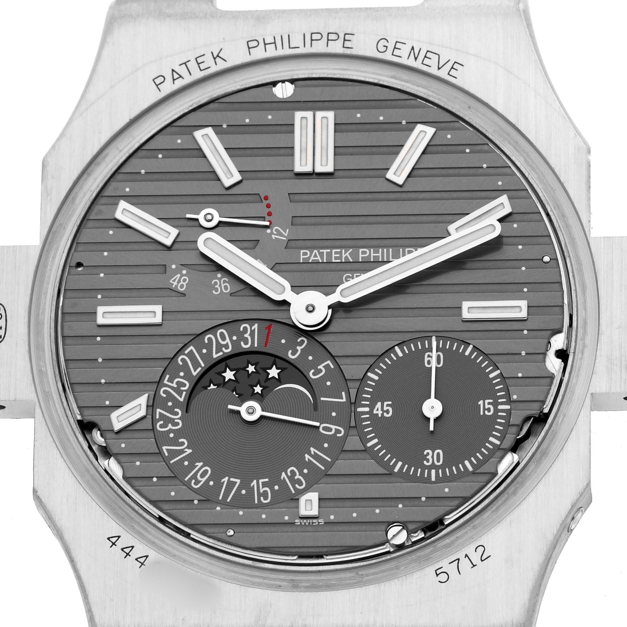 The image shows the face of a Patek Philippe Nautilus 5712G-001 Men's White Gold Grey Dial watch, displaying its dial, hands, and complications from a front angle.