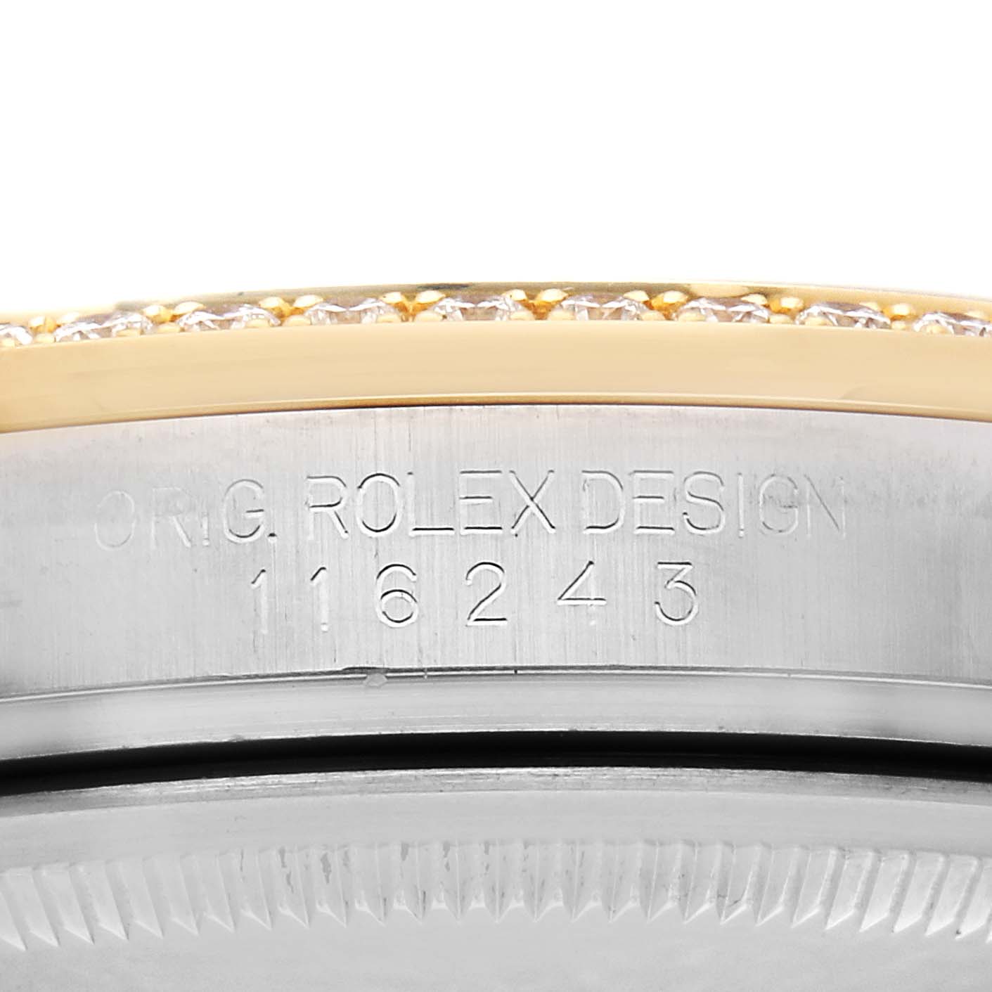 The image shows a close-up of the side view of a Rolex Datejust 116243 Men's Steel and Gold (two tone) Blue Dial, focusing on the engraved model number and a diamond-set bezel.