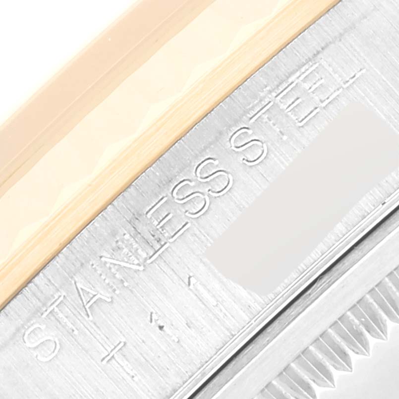 This close-up photo of a Rolex Datejust 16233 Men's Steel and Gold (two tone) Champagne Dial 16233 Men's Steel and Gold (two tone) Champagne Dial watch shows part of the bezel and the "Stainless Steel" engraving.