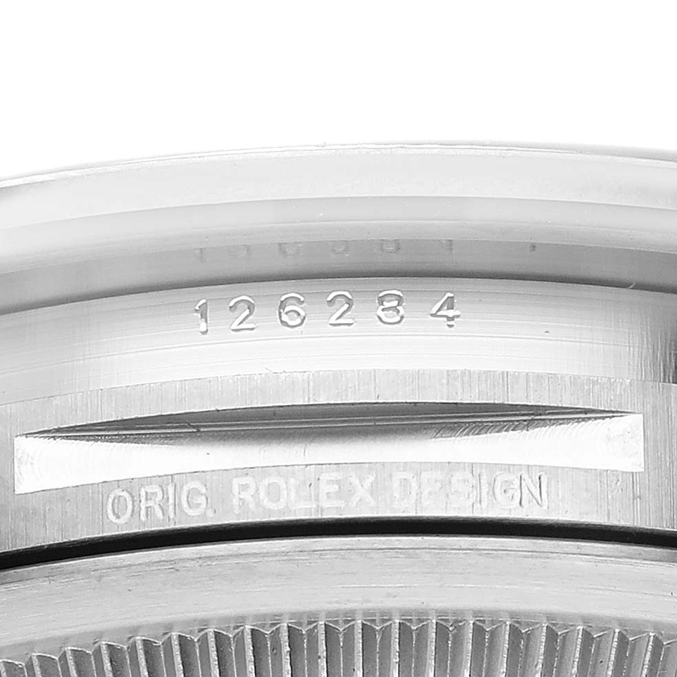 This image shows a close-up view of the model and "ORIG. ROLEX DESIGN" engravings on the side of a Rolex Datejust 126284 Men's Stainless Steel Silver Dial 126284 Men's Stainless Steel Silver Dial watch.