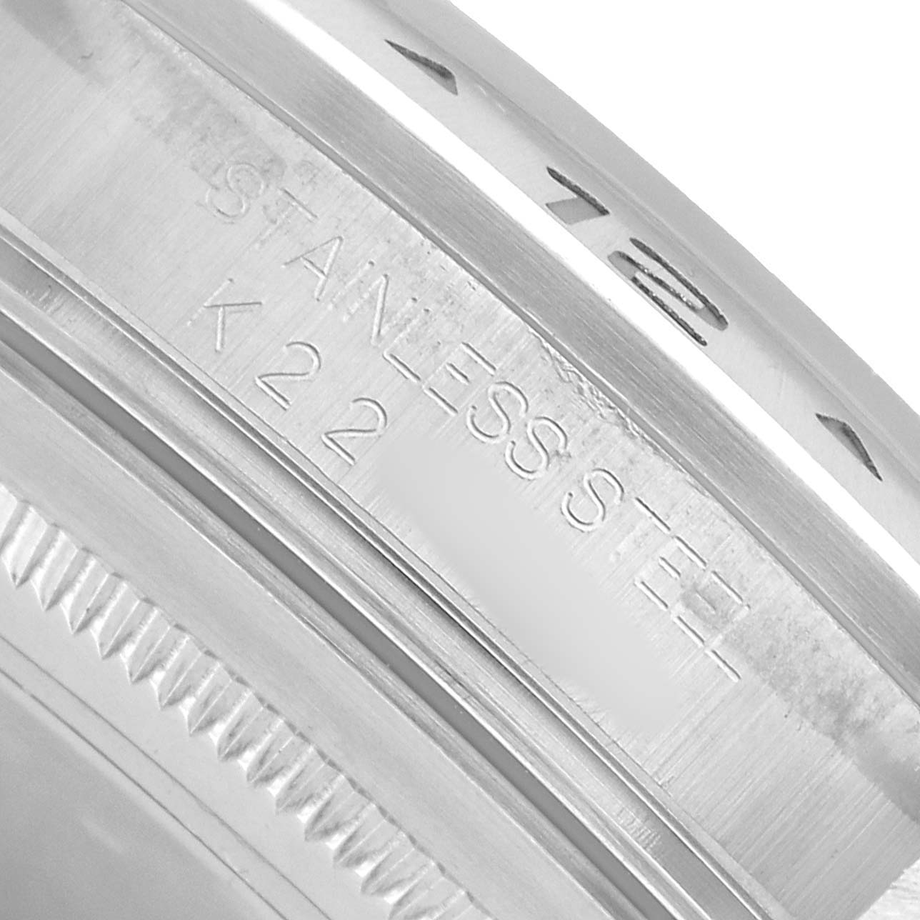 The image shows a close-up of the outer edge and bezel engraving of a Rolex Explorer 16570 Men's Stainless Steel White Dial watch.