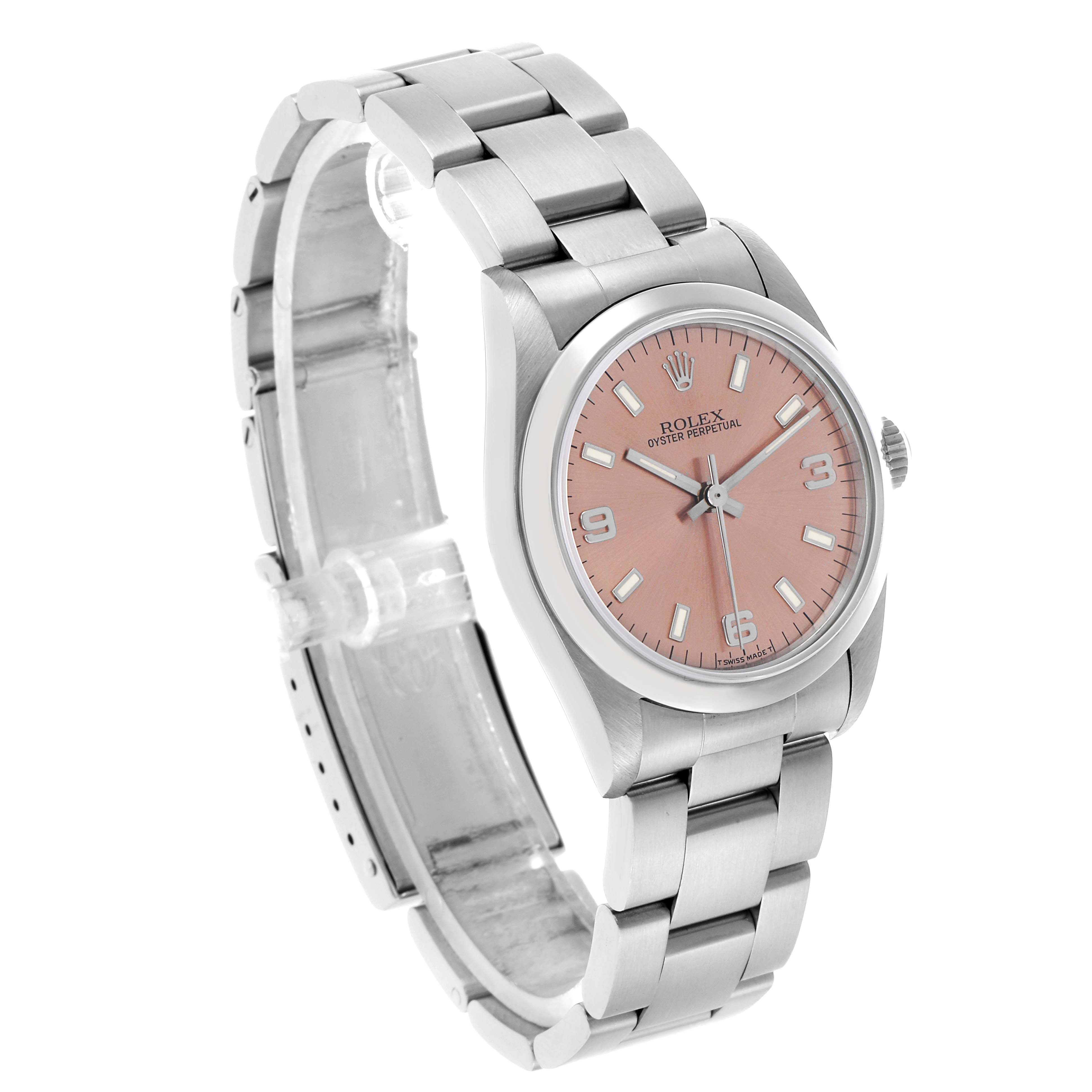 The Rolex Oyster Perpetual 67480 Women's Stainless Steel Pink Dial watch is shown at a three-quarter angle, highlighting the dial, bezel, and bracelet.