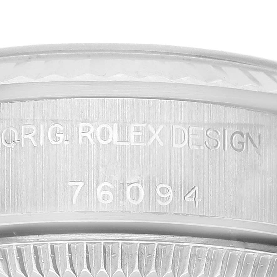 The image shows a close-up of the case side of a Rolex Oyster Perpetual 76094 Women
s Stainless Steel Pink Dial 76094 Women
s Stainless Steel Pink Dial watch, highlighting the engraved serial number and "ORIG. ROLEX DESIGN" inscription.
