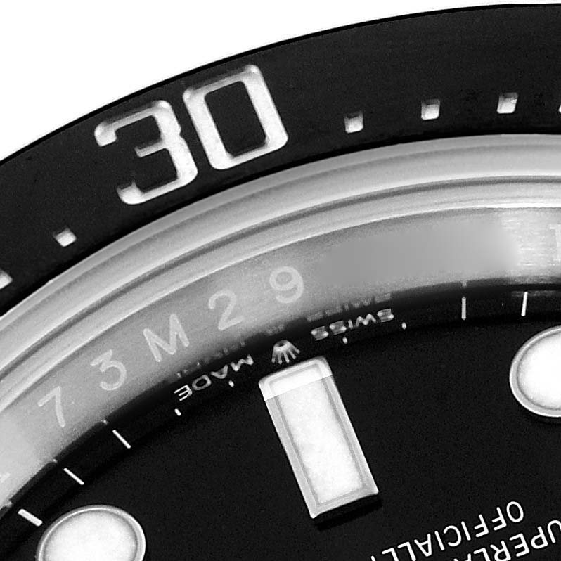 This close-up of a Rolex Sea-Dweller 126600 Men
s Stainless Steel Black Dial 126600 Men
s Stainless Steel Black Dial watch shows part of the dial, bezel with the 30-minute marker, and part of the indices.