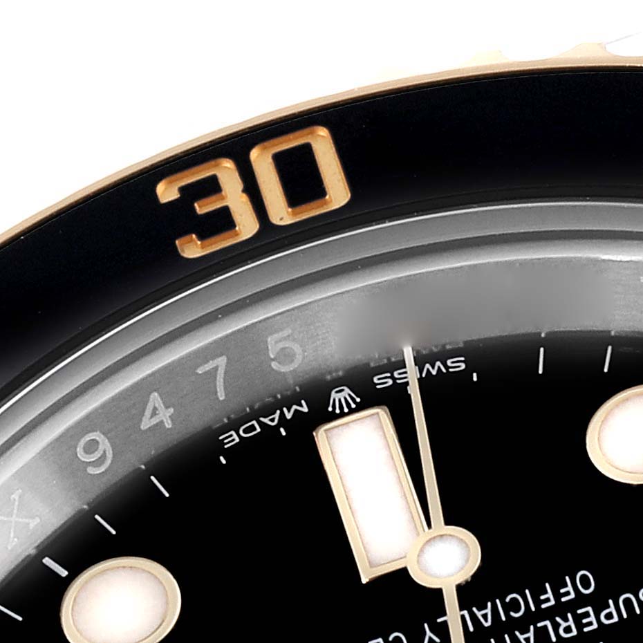This close-up of the Rolex Submariner 126613LN Men
s Steel and Gold (two tone) Black Dial 126613LN Men
s Steel and Gold (two tone) Black Dial shows the 30-minute marker on the bezel and part of the dial with hour markers and hands.