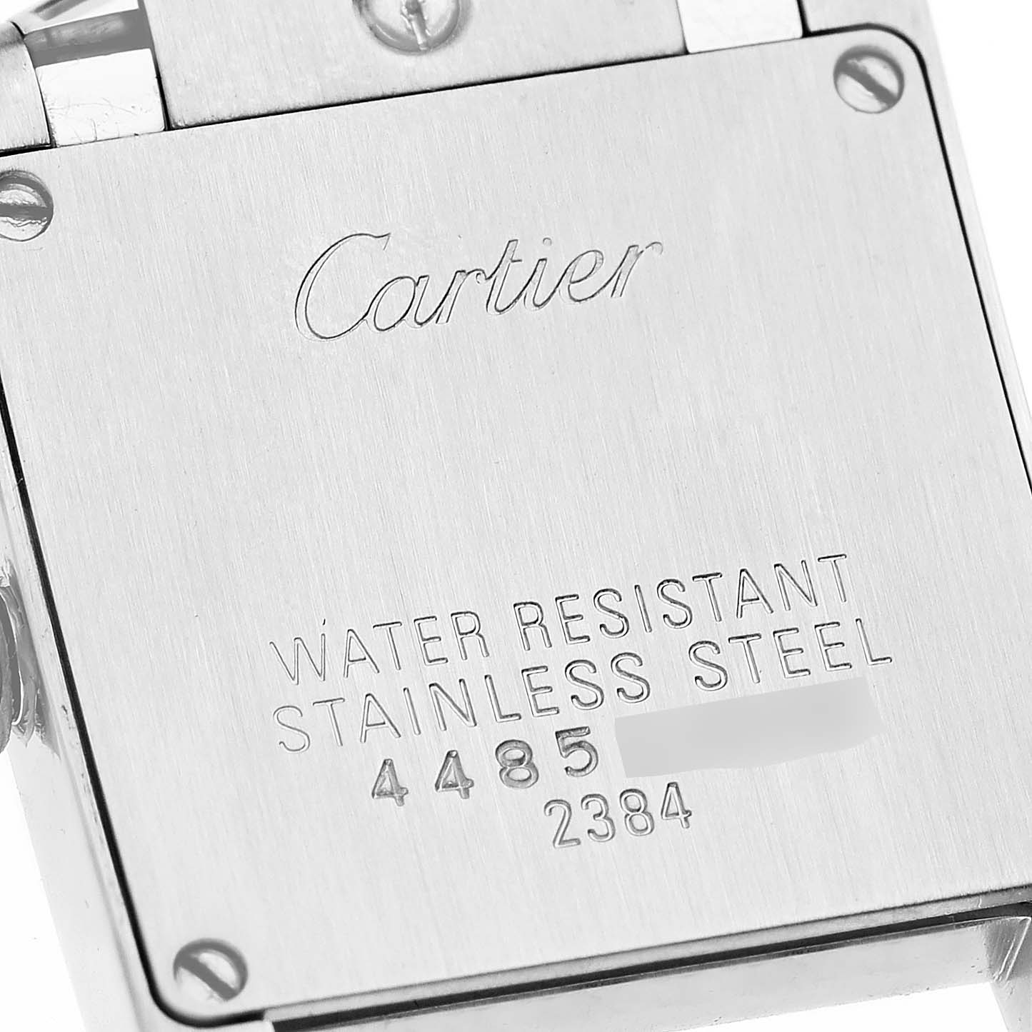 The image shows the stainless steel case back of a Cartier Tank Française watch, featuring the brand's engraving and model information.