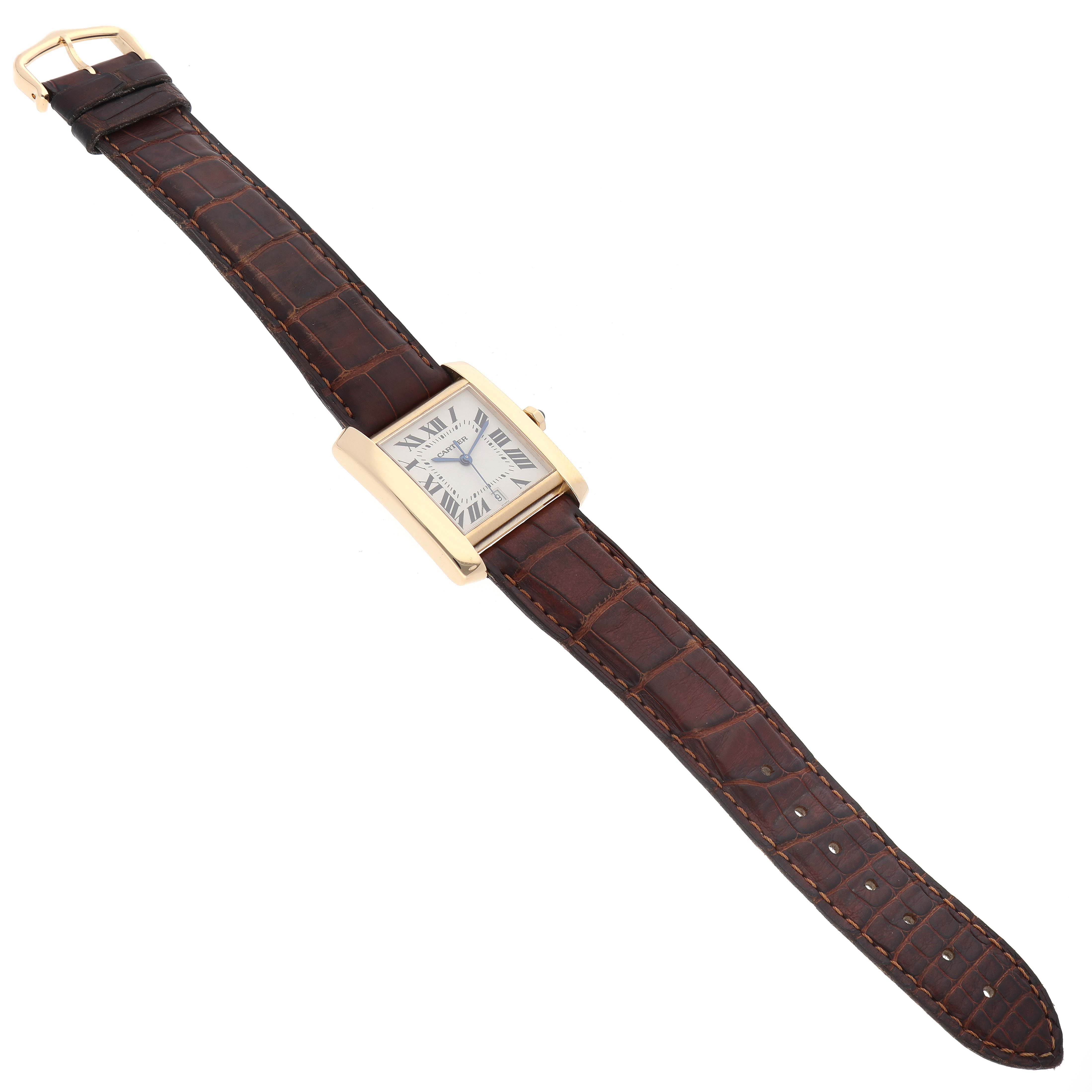 The Cartier Tank Francaise W5000156 Men
s Yellow Gold Silver Dial W5000156 Men
s Yellow Gold Silver Dial watch is shown in an angled top-down view, displaying its rectangular face and the full leather strap.