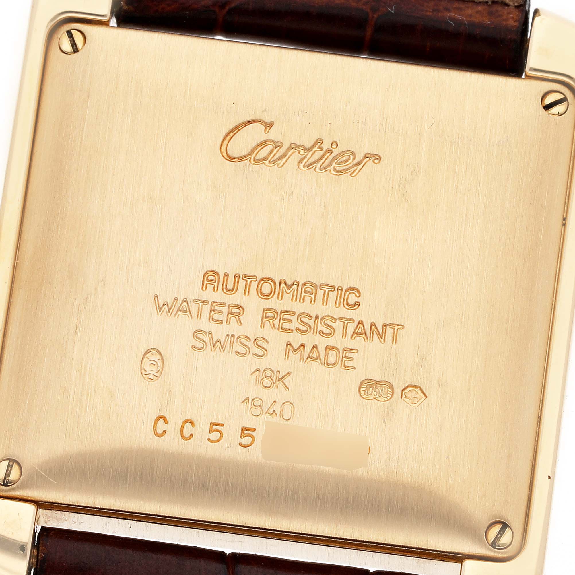 This image shows the back case of a Cartier Tank Française watch, displaying engravings and the leather strap attachment.