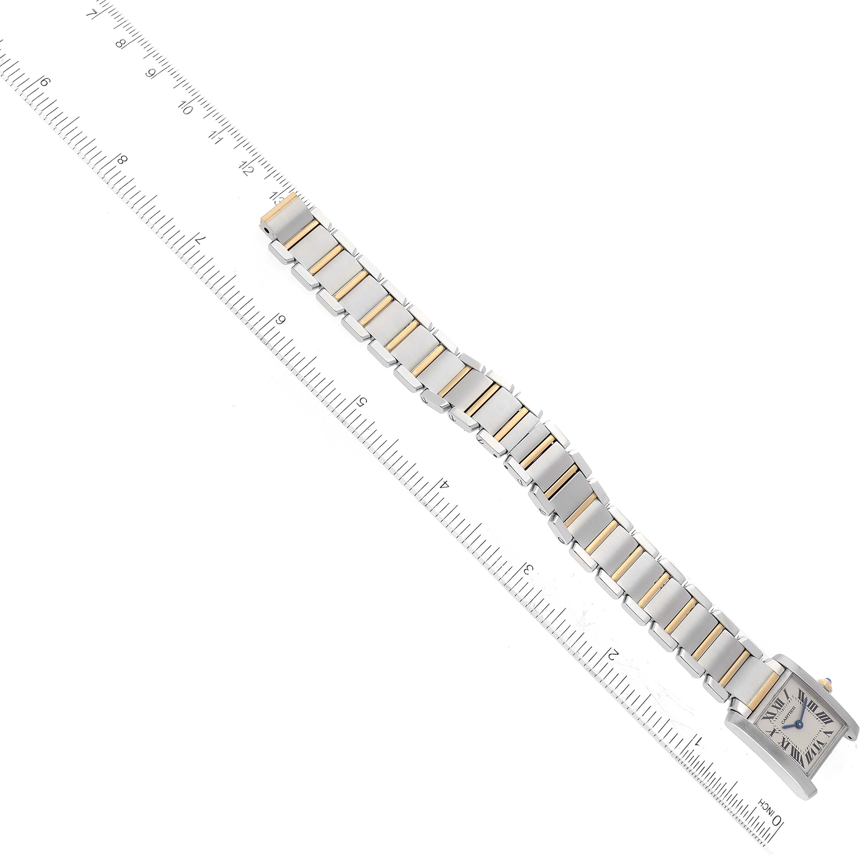This image shows an aerial view of a Cartier Tank Francaise W51007Q4 Women
s Steel and Gold (two tone) Silver Dial W51007Q4 Women
s Steel and Gold (two tone) Silver Dial watch, highlighting the watch face and metal bracelet, alongside a ruler for scale.