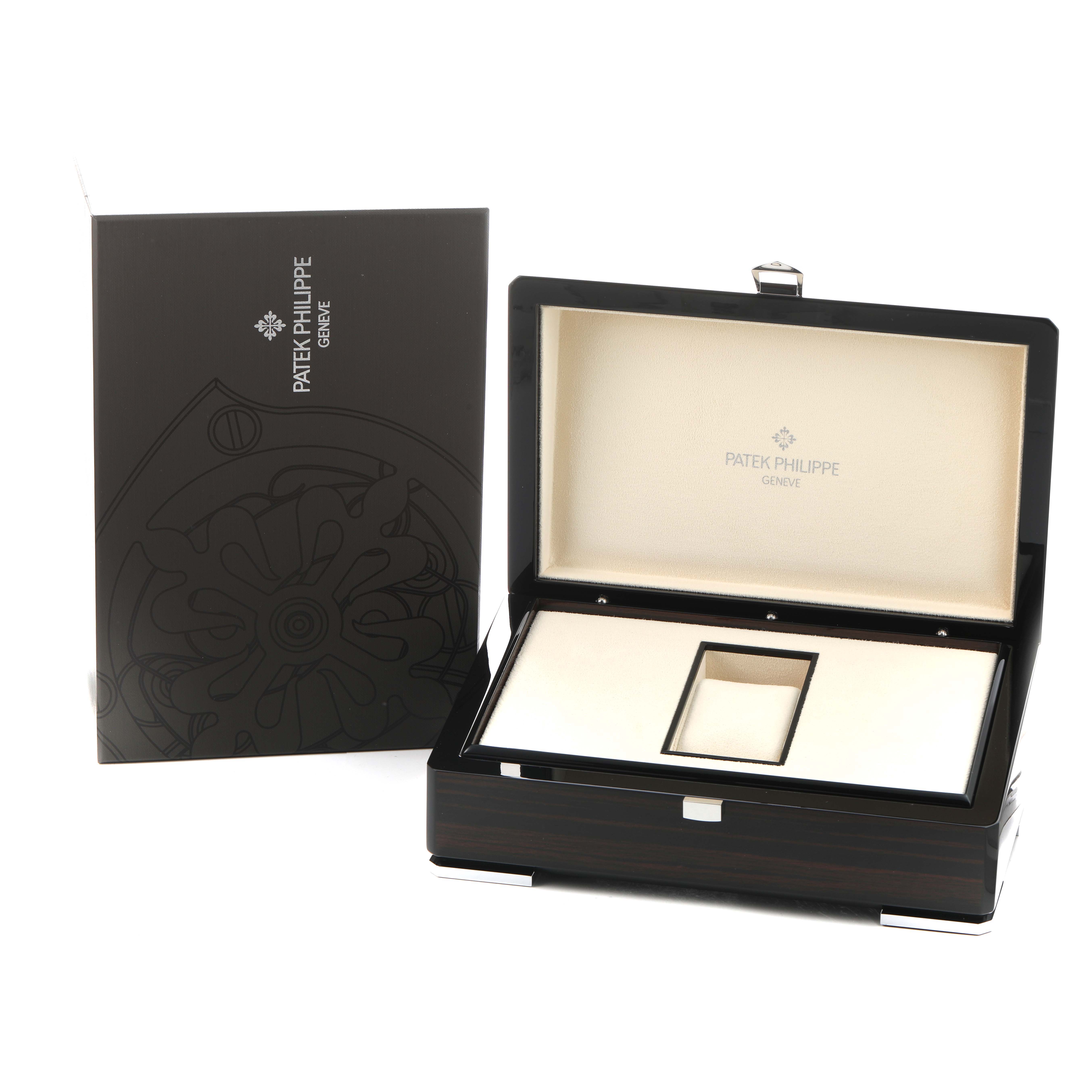 The image shows a Patek Philippe Calatrava 5119G Men's White Gold White Dial watch box open with a branded booklet beside it, viewed from a front angle.