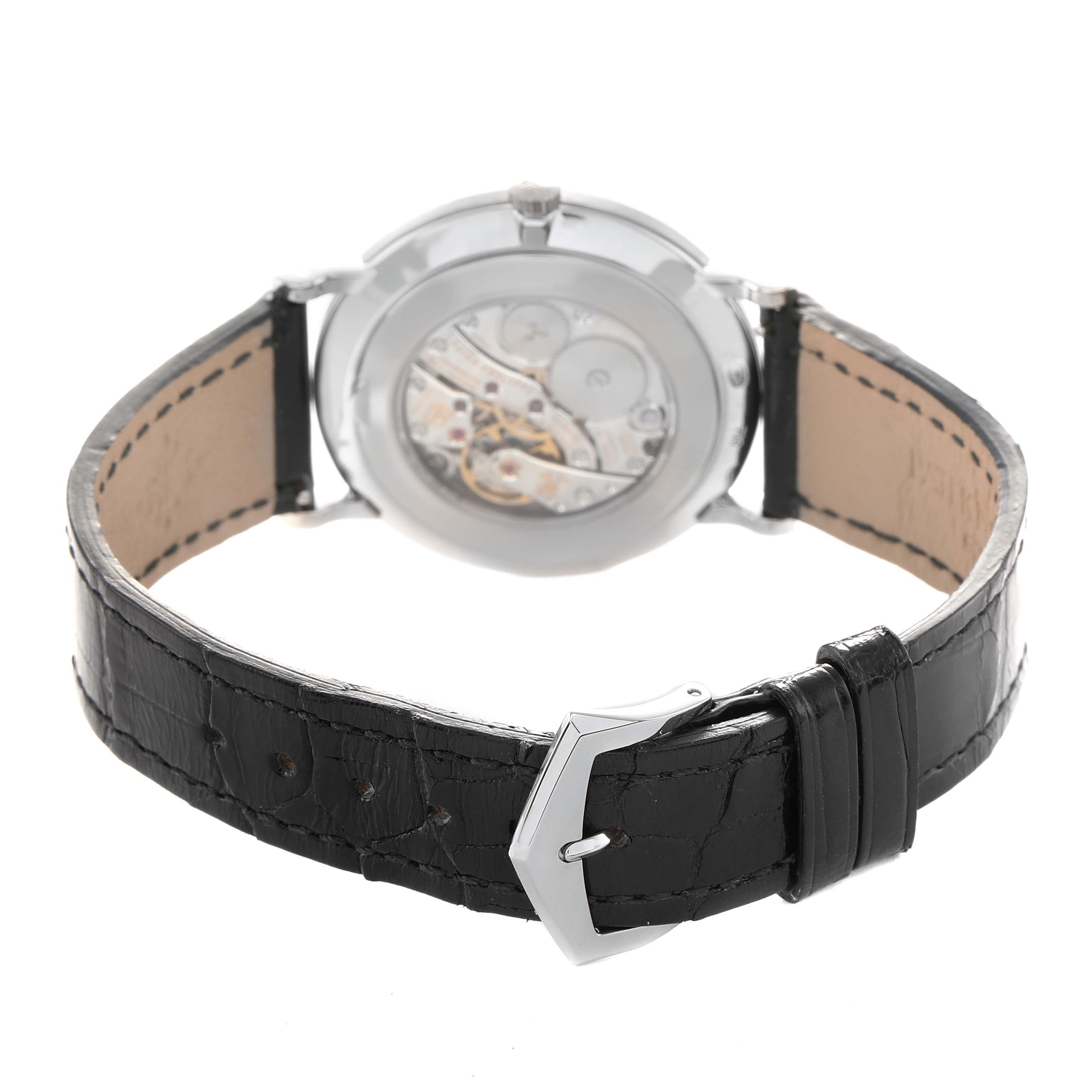 The Patek Philippe Calatrava 5119G Men's White Gold White Dial watch is shown from the back, highlighting the movement and black leather strap.