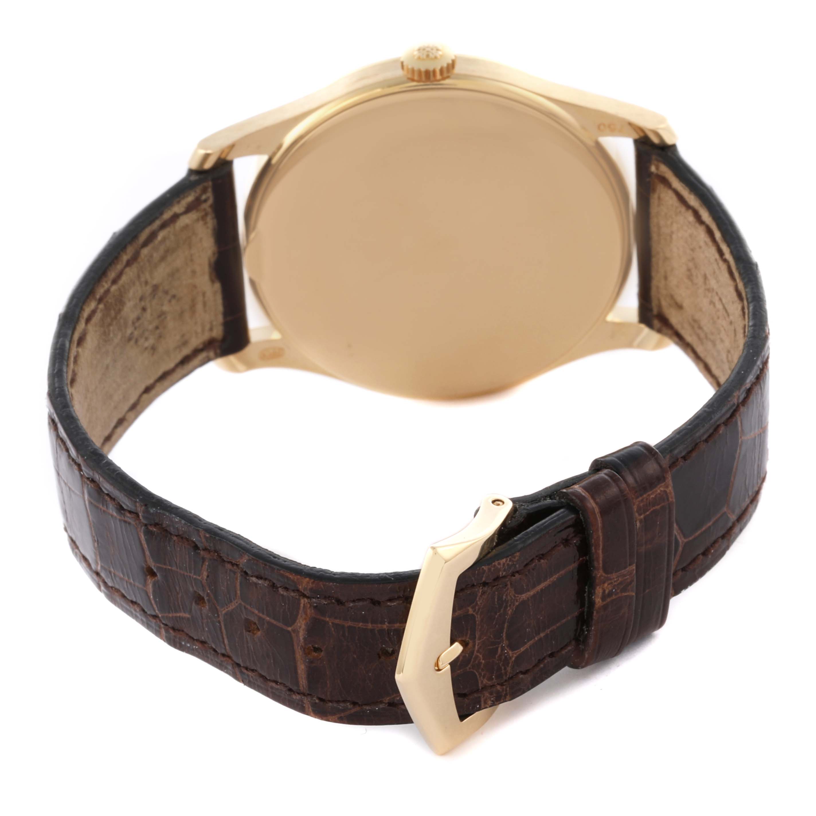 The image shows the back of a Patek Philippe Calatrava 5196J-001 Men's Yellow Gold Silver Dial 5196J-001 Men's Yellow Gold Silver Dial watch, including the case, crown, and leather strap with a buckle.