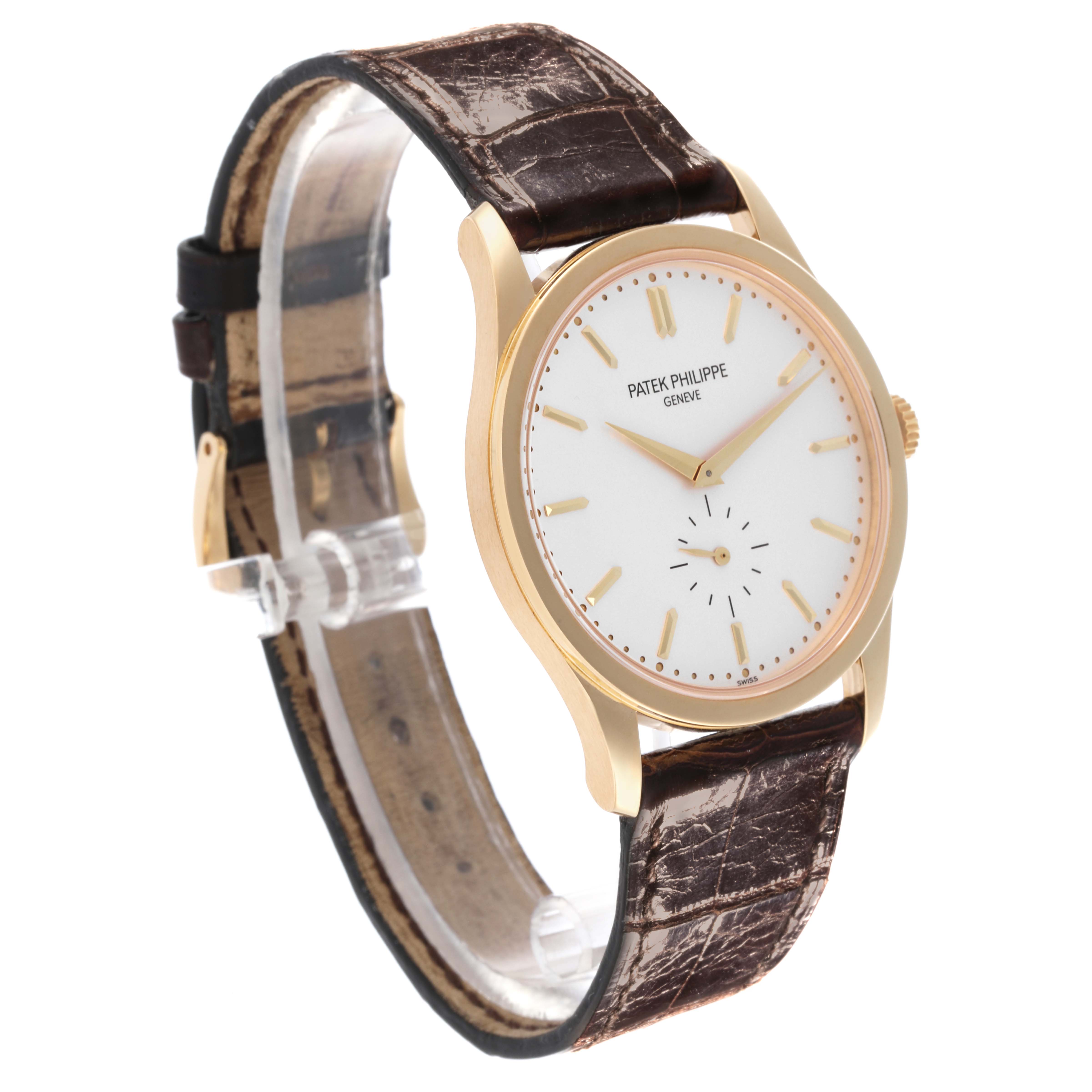 The Patek Philippe Calatrava 5196J-001 Men's Yellow Gold Silver Dial 5196J-001 Men's Yellow Gold Silver Dial watch is shown from a front angle with a clear view of its face and brown leather strap.