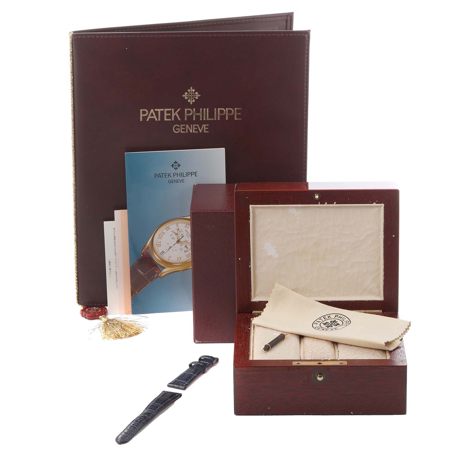 The image shows accessories of a Patek Philippe Complications 5035R-001 Men
s Rose Gold Silver Dial 5035R-001 Men
s Rose Gold Silver Dial model, including a case, strap, cleaning cloth, and booklet.