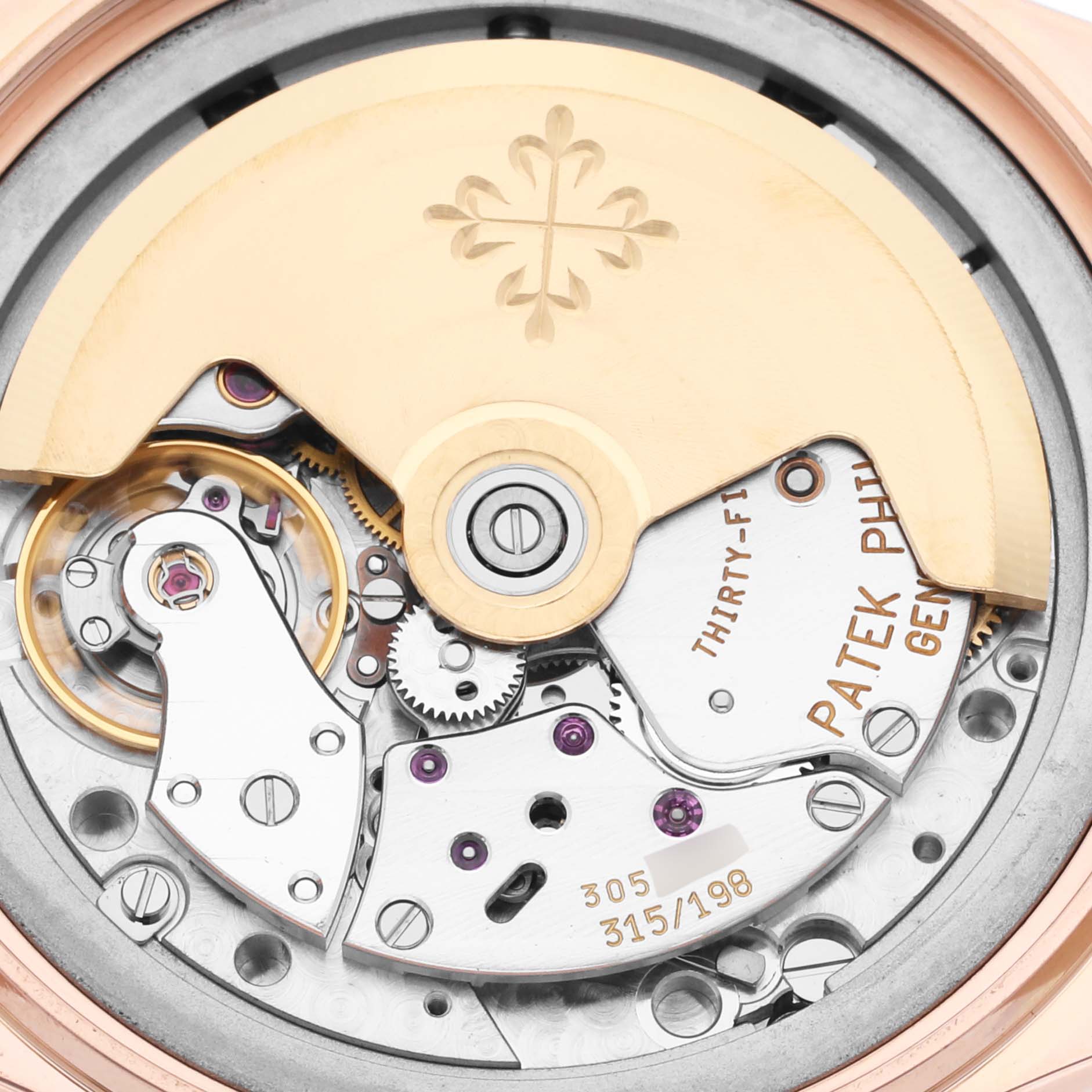The image shows the movement and intricate gears of the Patek Philippe Complications 5035R-001 Men
s Rose Gold Silver Dial 5035R-001 Men
s Rose Gold Silver Dial watch from the back.