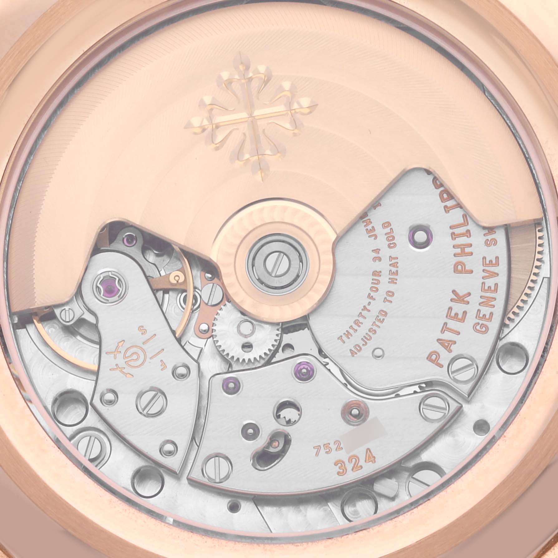 The image shows the movement of a Patek Philippe Complications 5205R - 011 Men's Rose Gold Green Dial 5205R - 011 Men's Rose Gold Green Dial watch, highlighting the intricate gears and engravings from a rear view.