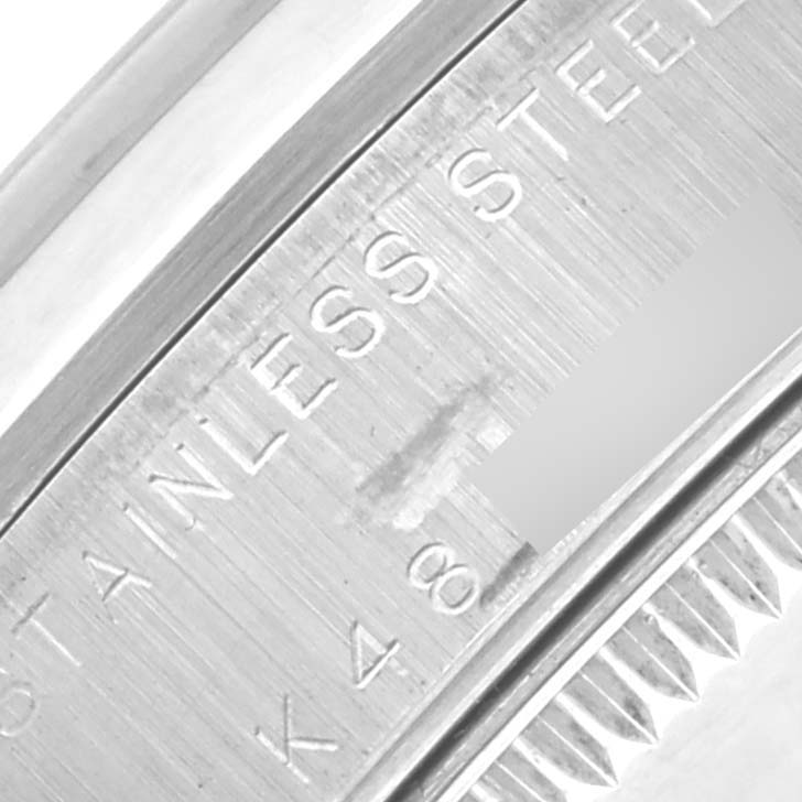 The image shows a close-up of the Rolex Mid-Size 78240 Women's Stainless Steel Silver Dial 78240 Women's Stainless Steel Silver Dial model case with "STAINLESS STEEL" and partial serial number engraving.