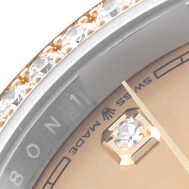 The image shows a close-up of a Rolex Datejust 126283RBR Men's Steel and Gold (two tone) Champagne Dial 126283RBR Men's Steel and Gold (two tone) Champagne Dial watch, focusing on the bejeweled bezel, part of the dial, and an index marker.