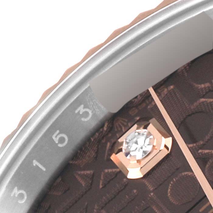 This close-up image of a Rolex Datejust 126231 Men's Steel and Gold (two tone) Brown Dial 126231 Men's Steel and Gold (two tone) Brown Dial watch shows part of the bezel, a diamond hour marker, and the 3-5 minute markers.