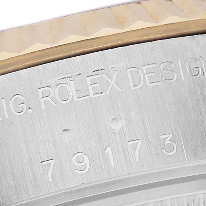 The image shows a close-up of the side engraving and bezel of a Rolex Datejust 79173 Women's Steel and Gold (two tone) Champagne Dial 79173 Women's Steel and Gold (two tone) Champagne Dial watch.