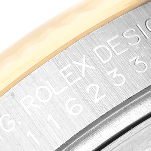 This image shows a close-up of the engraved casing of a Rolex Datejust 116233 Men's Steel and Gold (two tone) Champagne Dial 116233 Men's Steel and Gold (two tone) Champagne Dial watch.