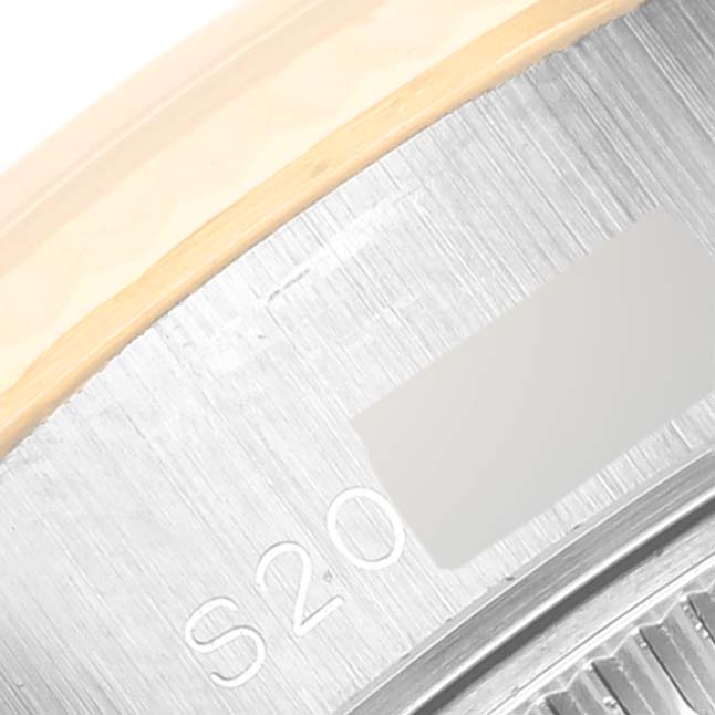 This is a close-up of the side case of a Rolex Datejust 69173 Women's Steel and Gold (two tone) Champagne Dial 69173 Women's Steel and Gold (two tone) Champagne Dial watch showing a serial number engraving and part of the bezel.