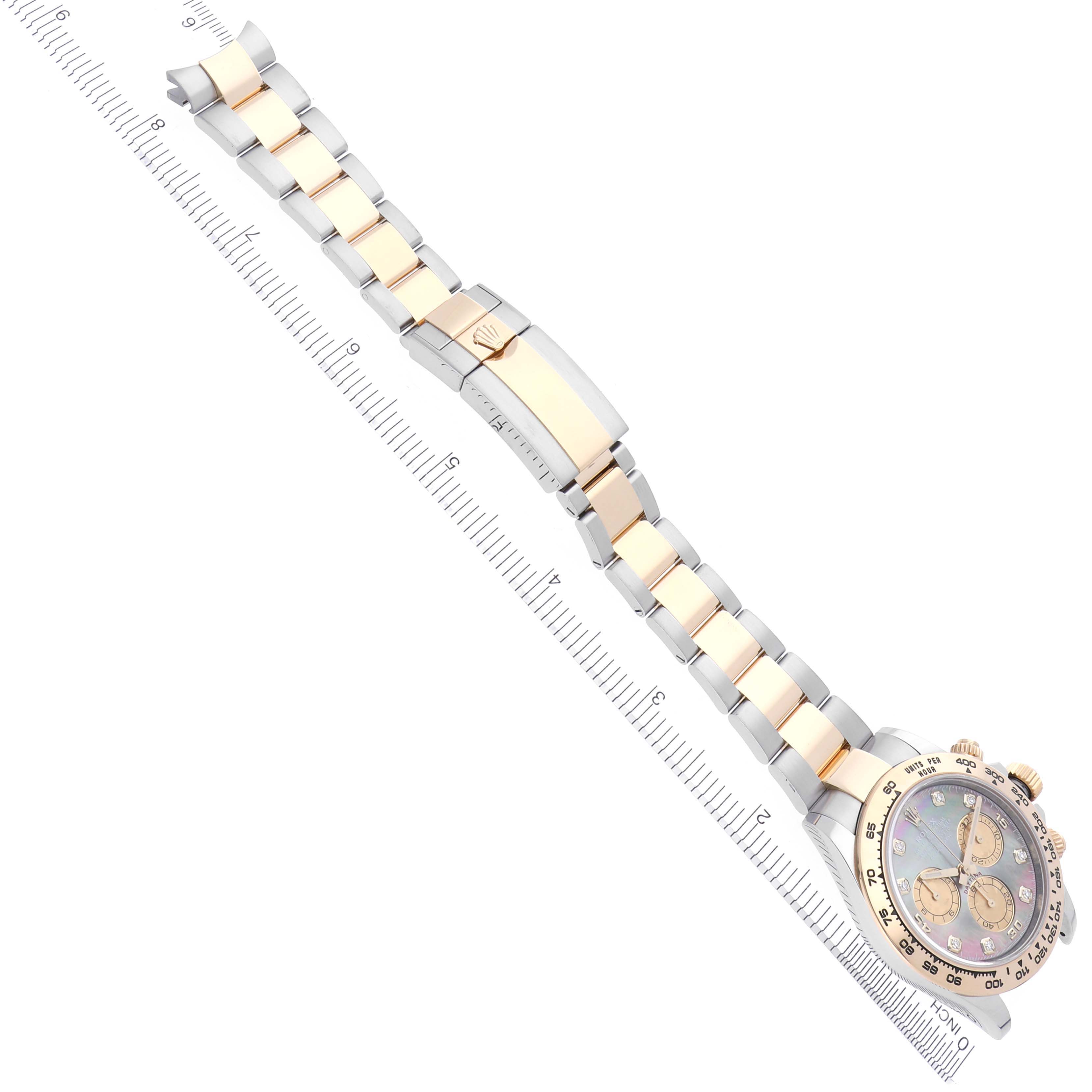 The Rolex Daytona 116503 Men's Steel and Gold (two tone) Mother of Pearl Dial 116503 Men's Steel and Gold (two tone) Mother of Pearl Dial watch is shown from a top view, highlighting its full bracelet and face with a ruler beside it.